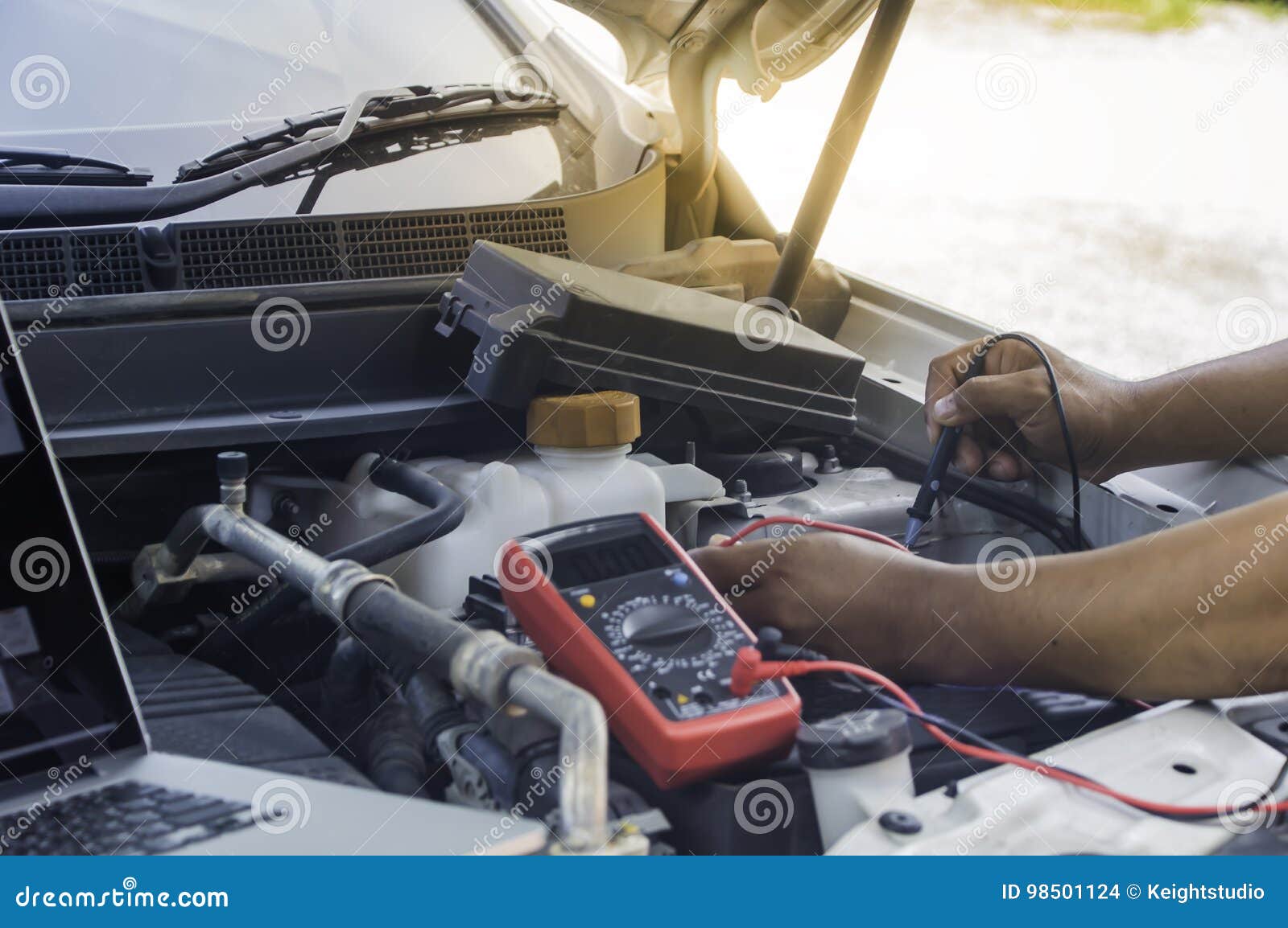 Auto Mechanic Uses a Multimeter Voltmeter. Stock Photo Image of