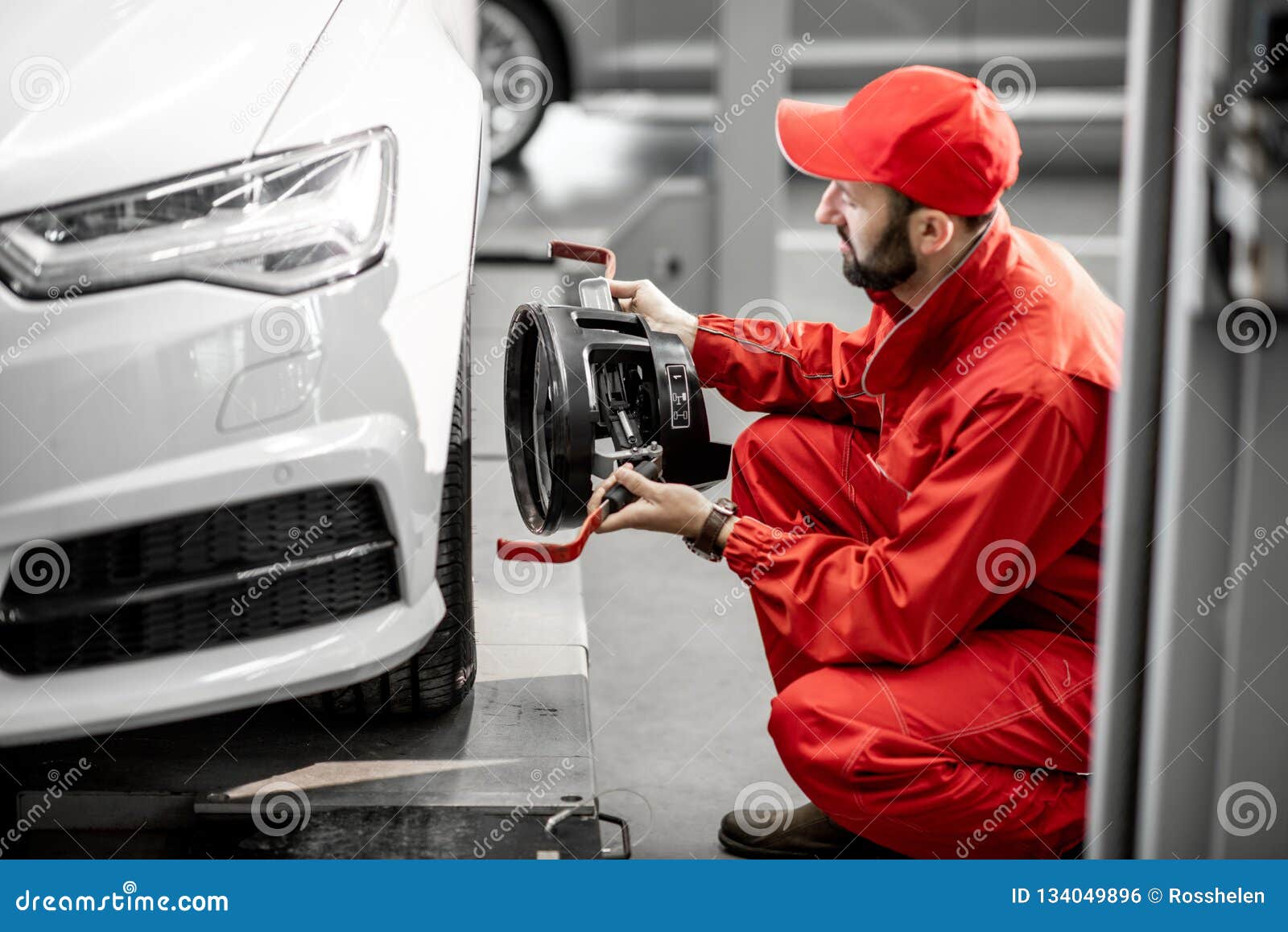 Auto Mechanics Making Wheel Alignment at the Car Service Stock Photo