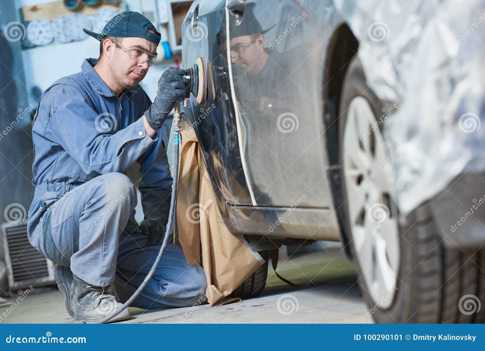 auto repairman grinding autobody bonnet