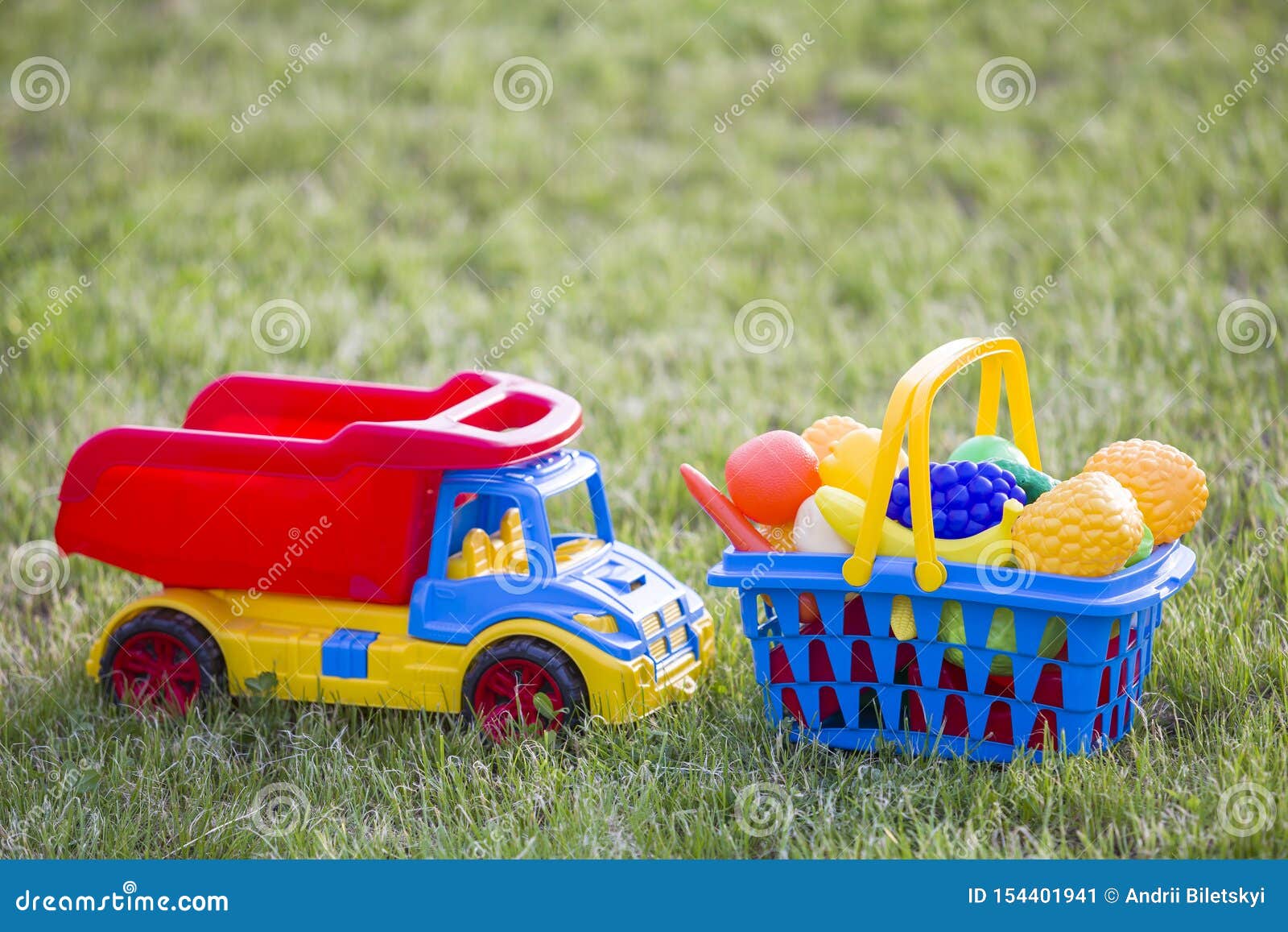 Auto Truckand Ein Korb Mit Spielzeugobst Und Gemüse - Helle Bunte  Plastikspielwaren Für Kinder Draußen am Sonnigen Sommertag Stockbild - Bild  von abnehmer, auto: 154401941