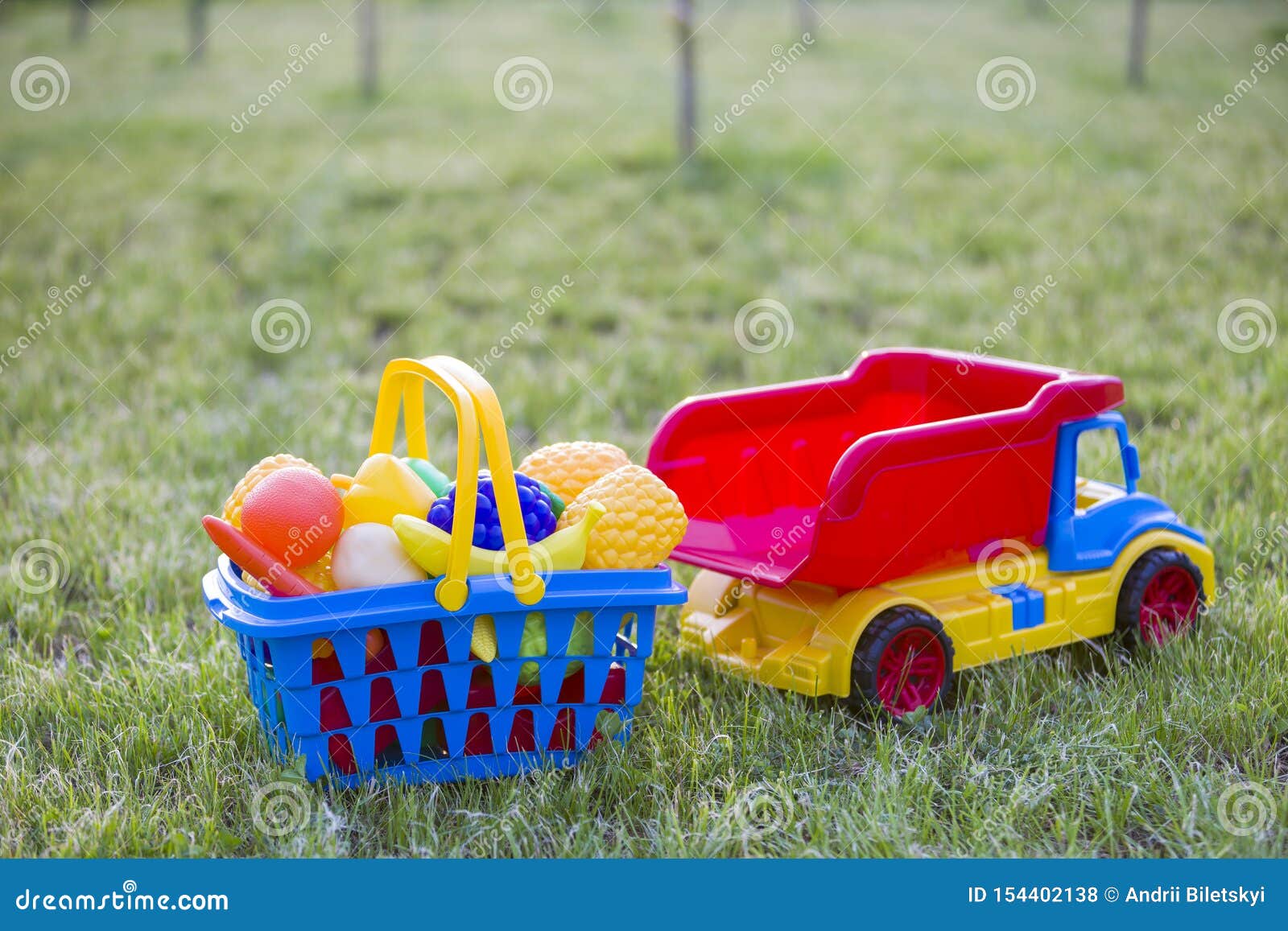 Auto Truckand Ein Korb Mit Spielzeugobst Und Gemüse - Helle Bunte  Plastikspielwaren Für Kinder Draußen am Sonnigen Sommertag Stockfoto - Bild  von eingabe, kaufen: 154402138