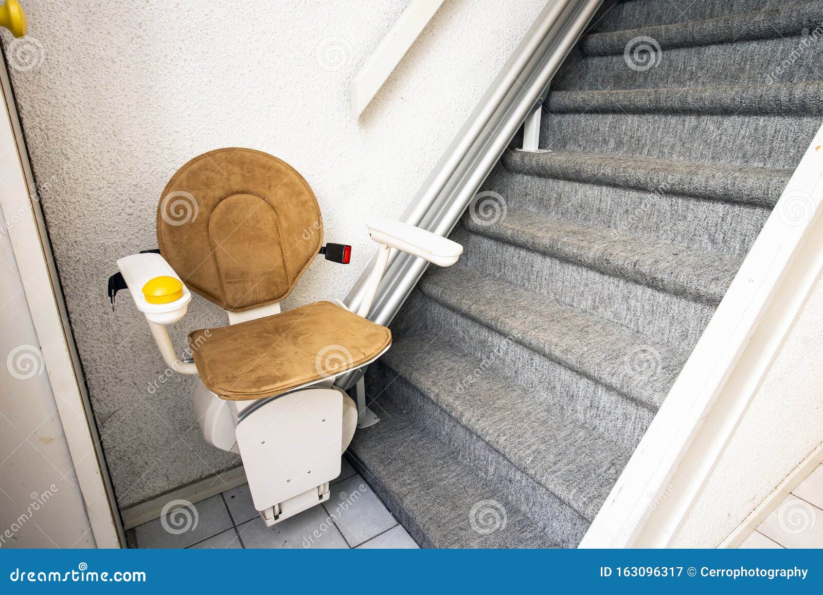 automatic stair lift on staircase taking elderly people and disabled persons up and down in a house