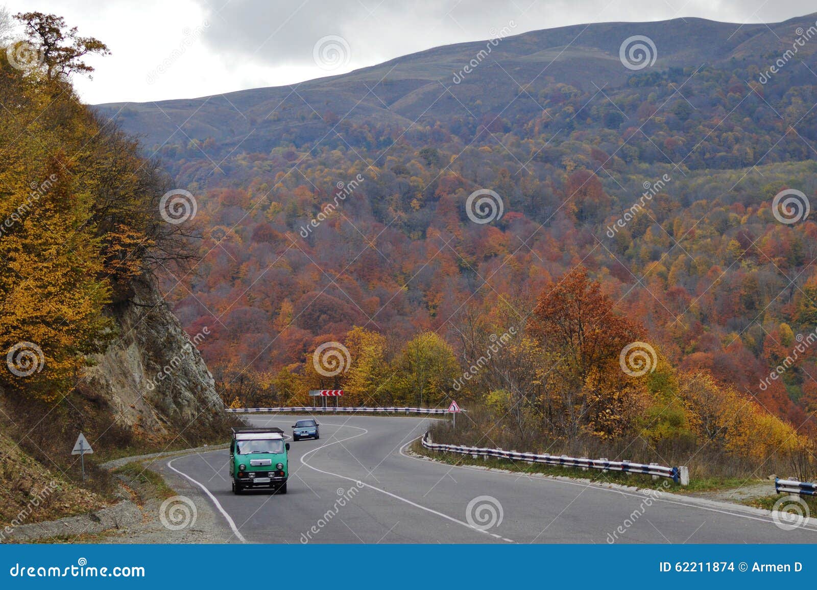 Automn in bergen. Een oude sovjetauto die bergop een schilderachtige berg kronkelige weg gaan De herfst in Armenië