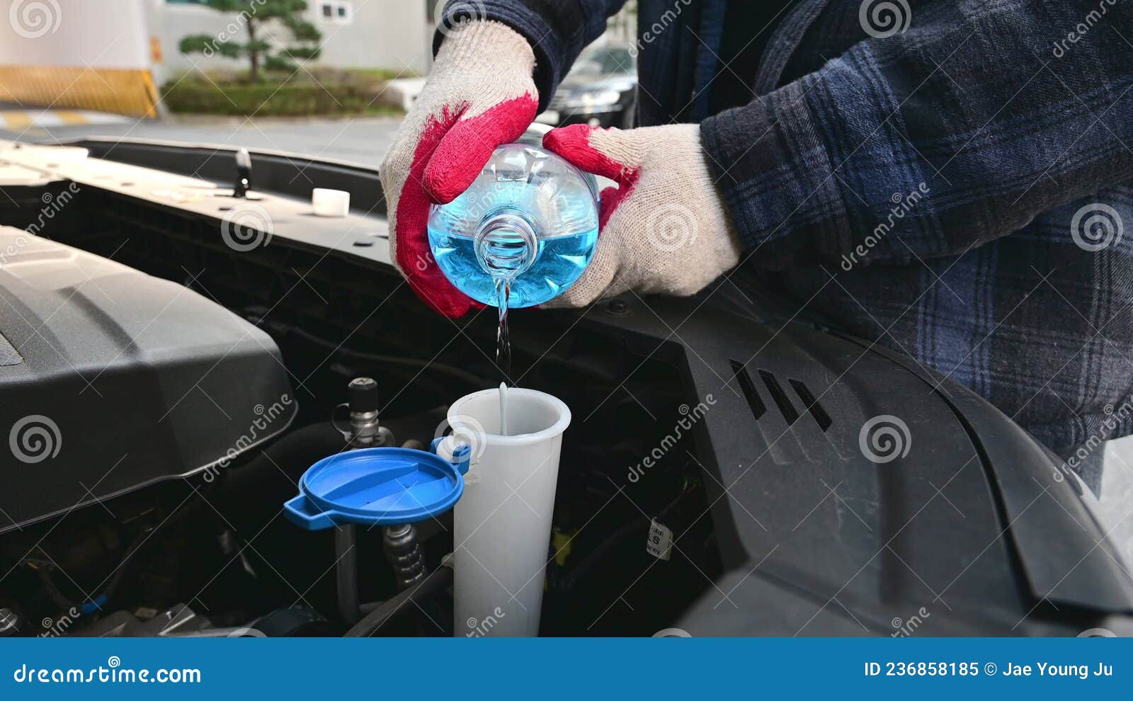 Automobile Maintenance. Filling the Windshield Washer Fluid on a Car