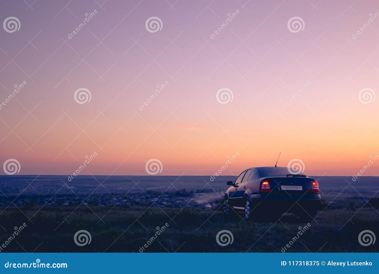 Automobile nera nel campo al tramonto