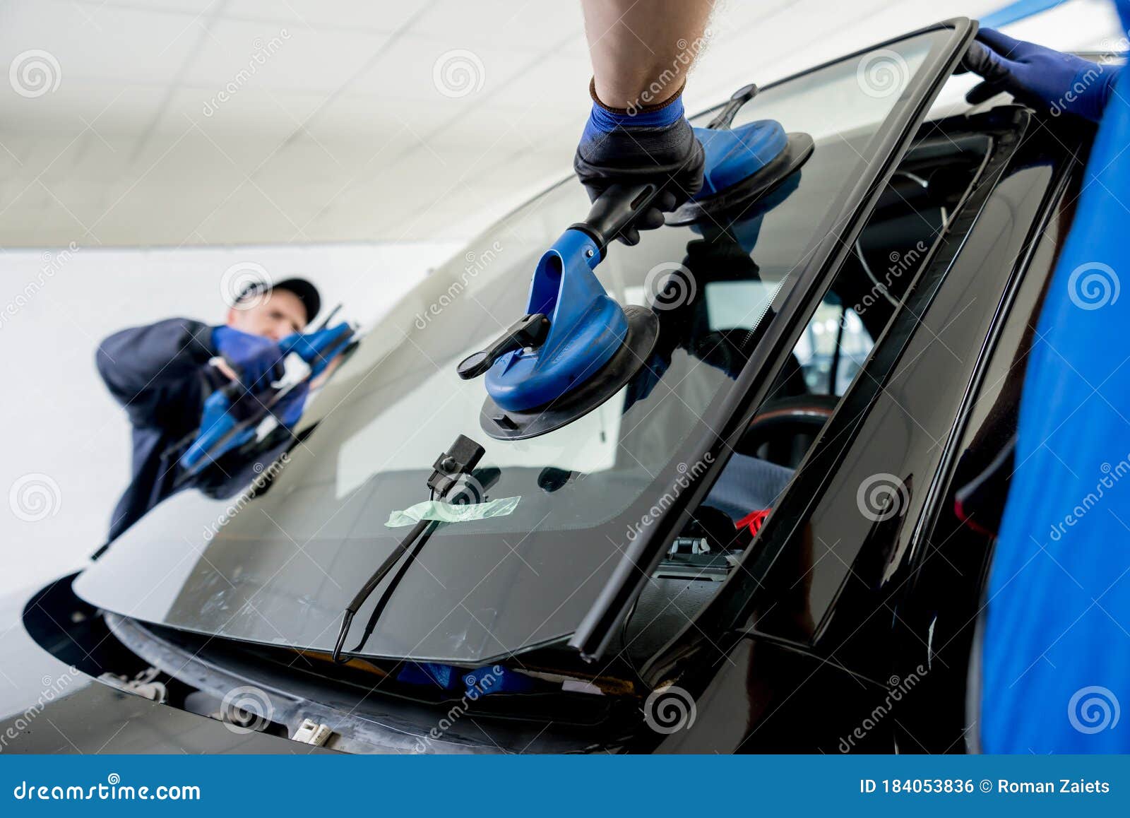 automobile special workers replacing windscreen of a car in auto service