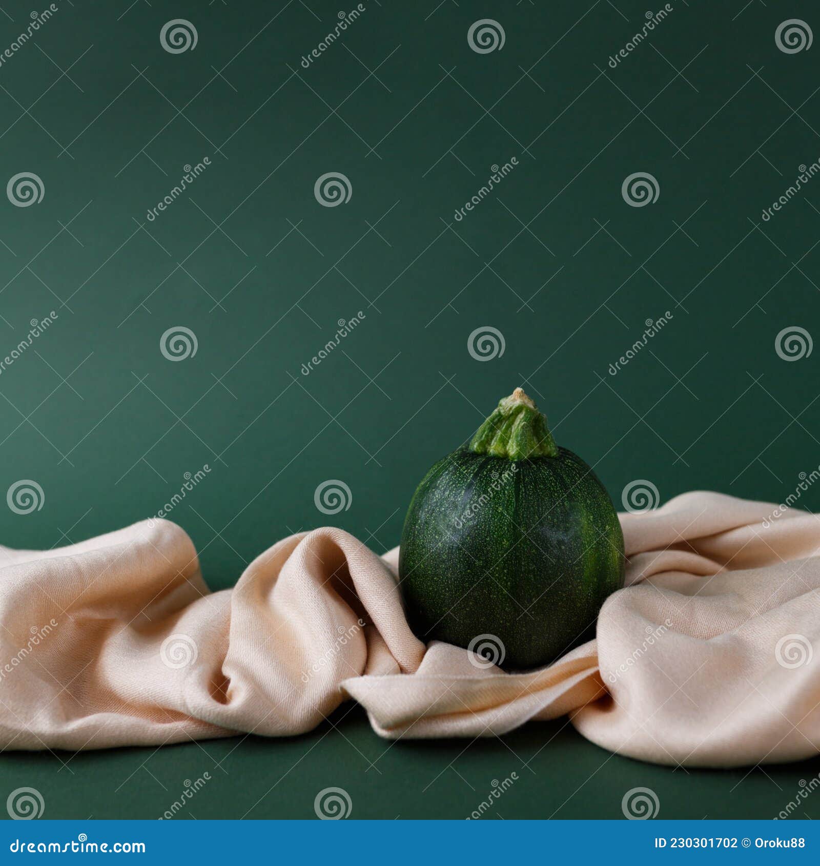 autumn concept of zucchini  on a green background with saten fabric cloth