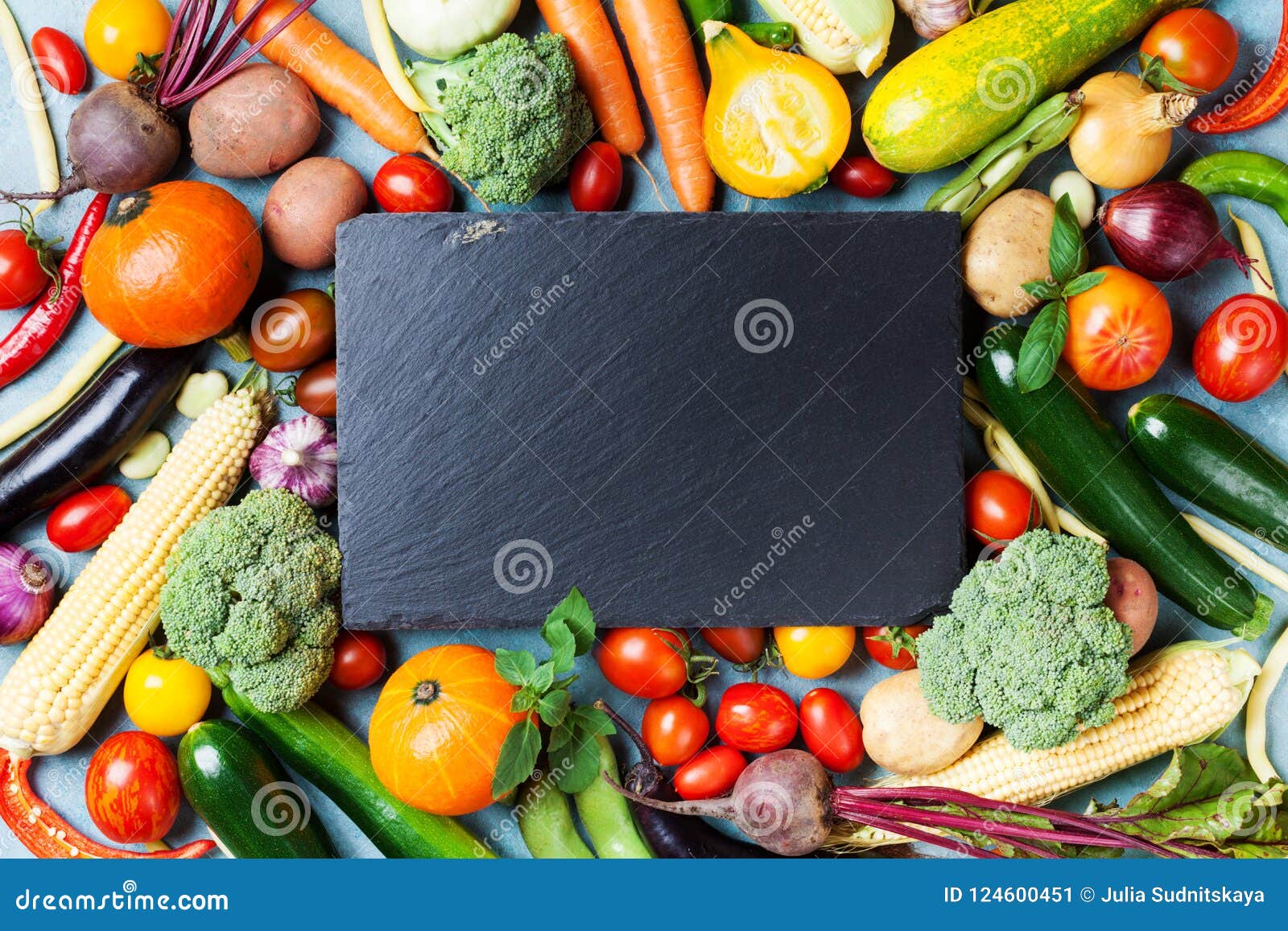 autumn farm vegetables, root crops and slate cutting board top view with copy space for menu or recipe. healthy food background.