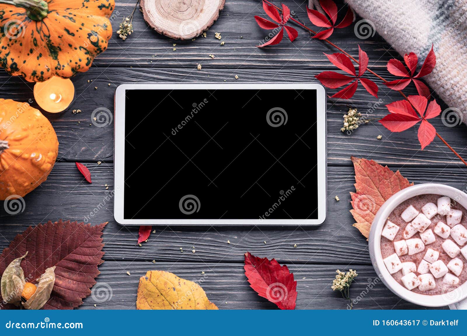 autumn holiday background with tablet computer screen mock up on wooden table
