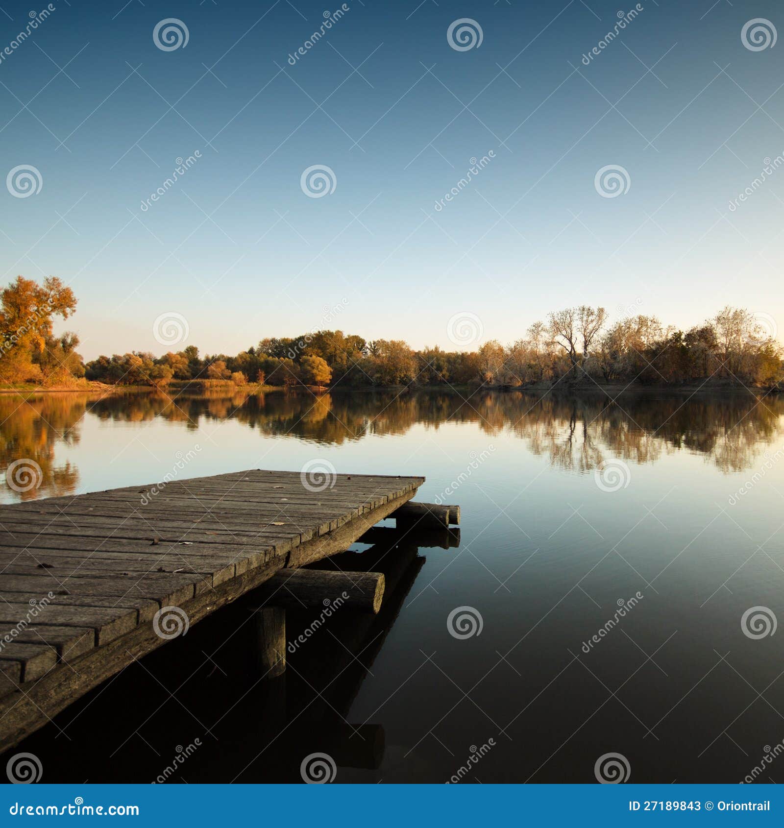 autumn lake scene with wooden dock