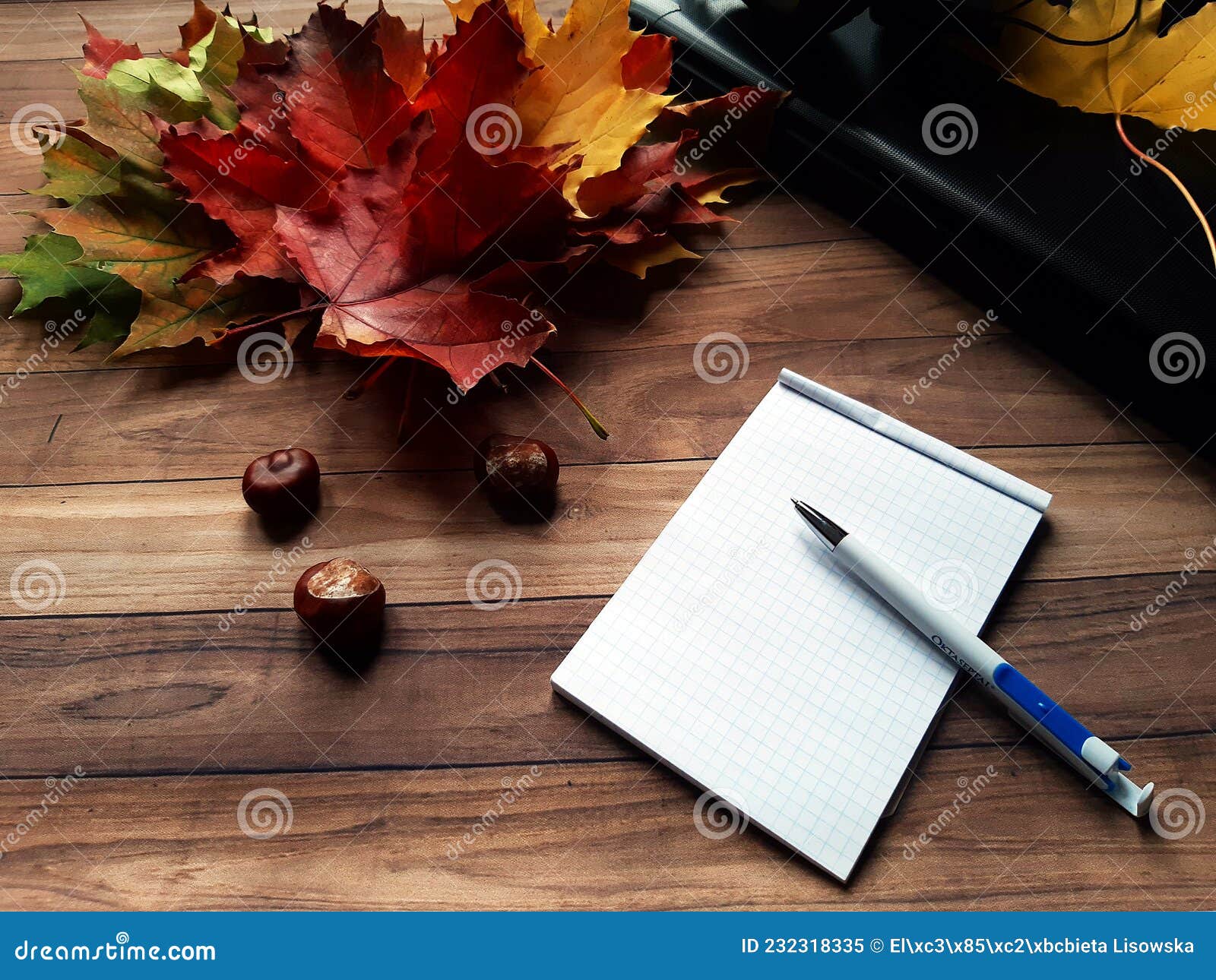 autumn leaves and chestnuts on a wooden table