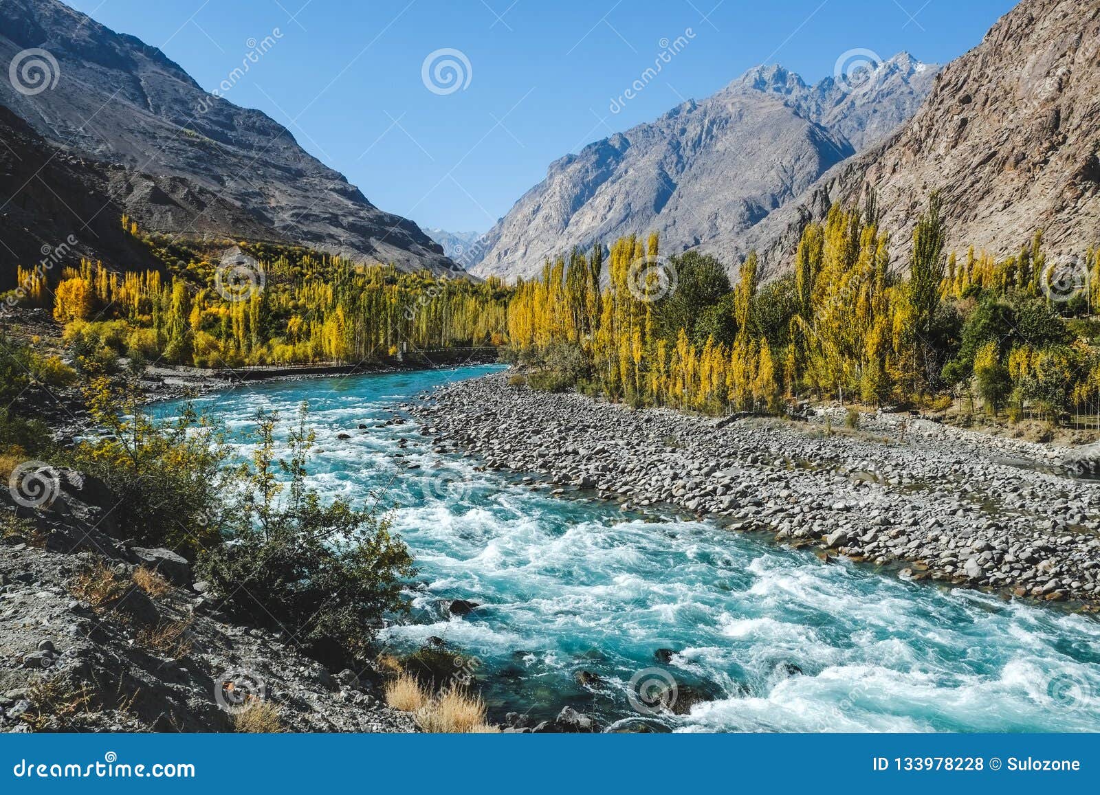 autumn scene, blue turqu oise water of gilgit river flowing through gupis,pakistan.