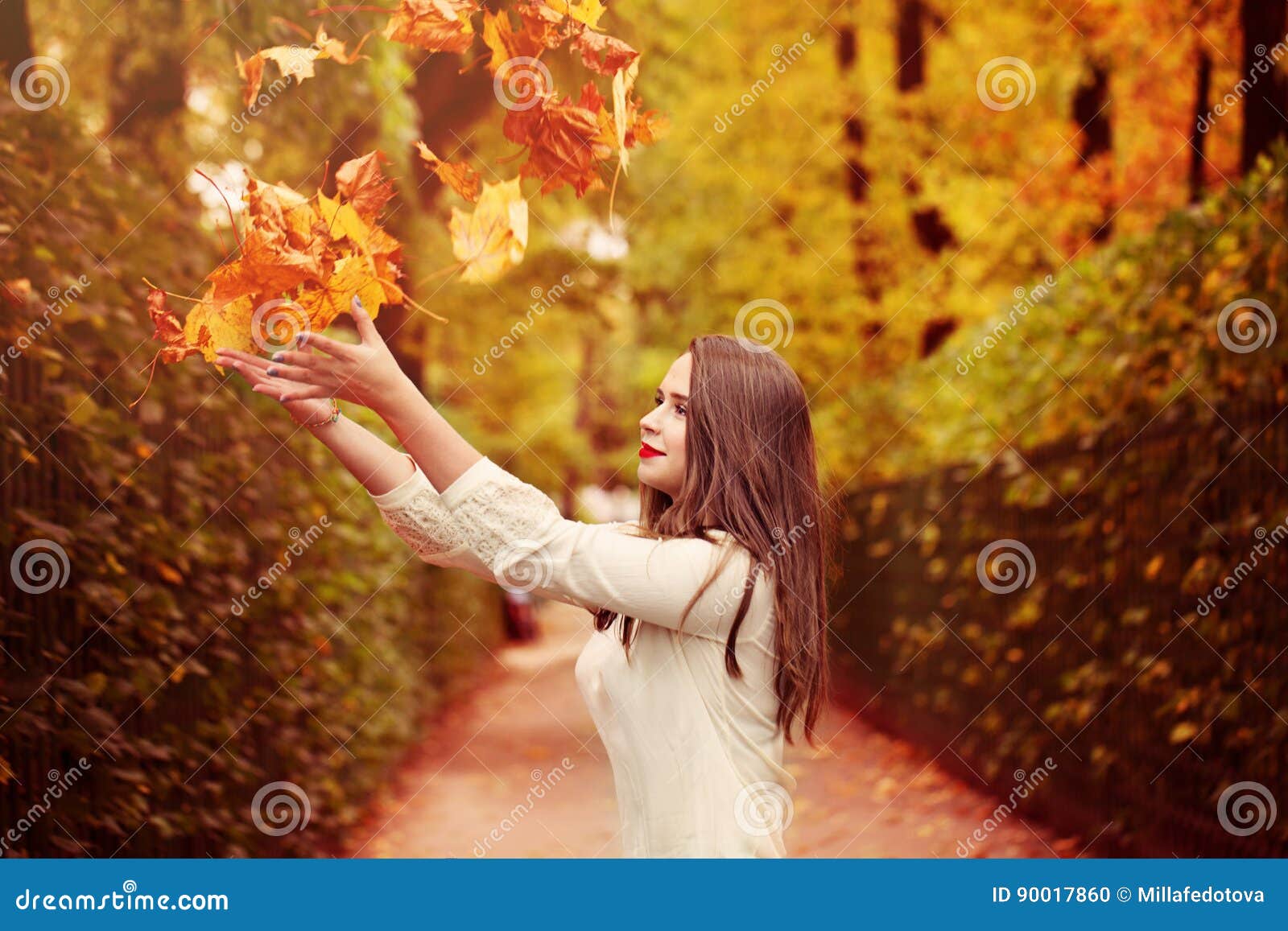 autumn woman outdoors. woman fasion model throwing up fal