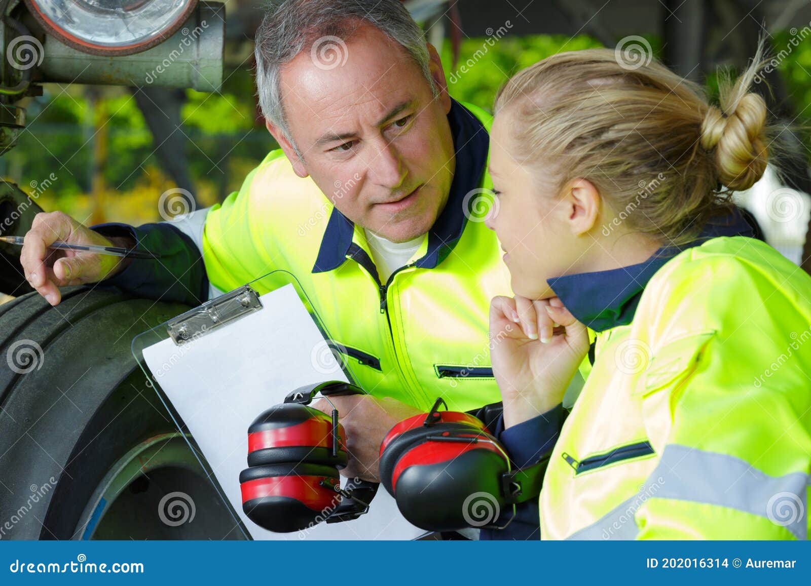 aviation mechanic with female apprentice by aircraft landing gear