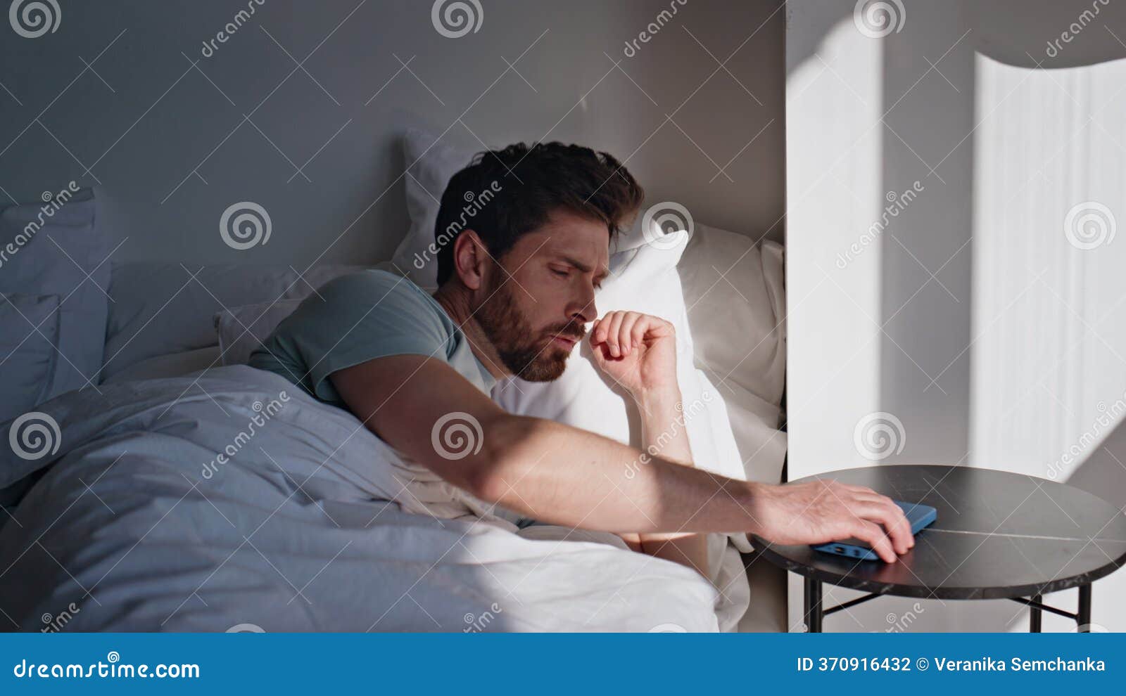 awaking brunette looking smartphone screen bed closeup. smiling man read message