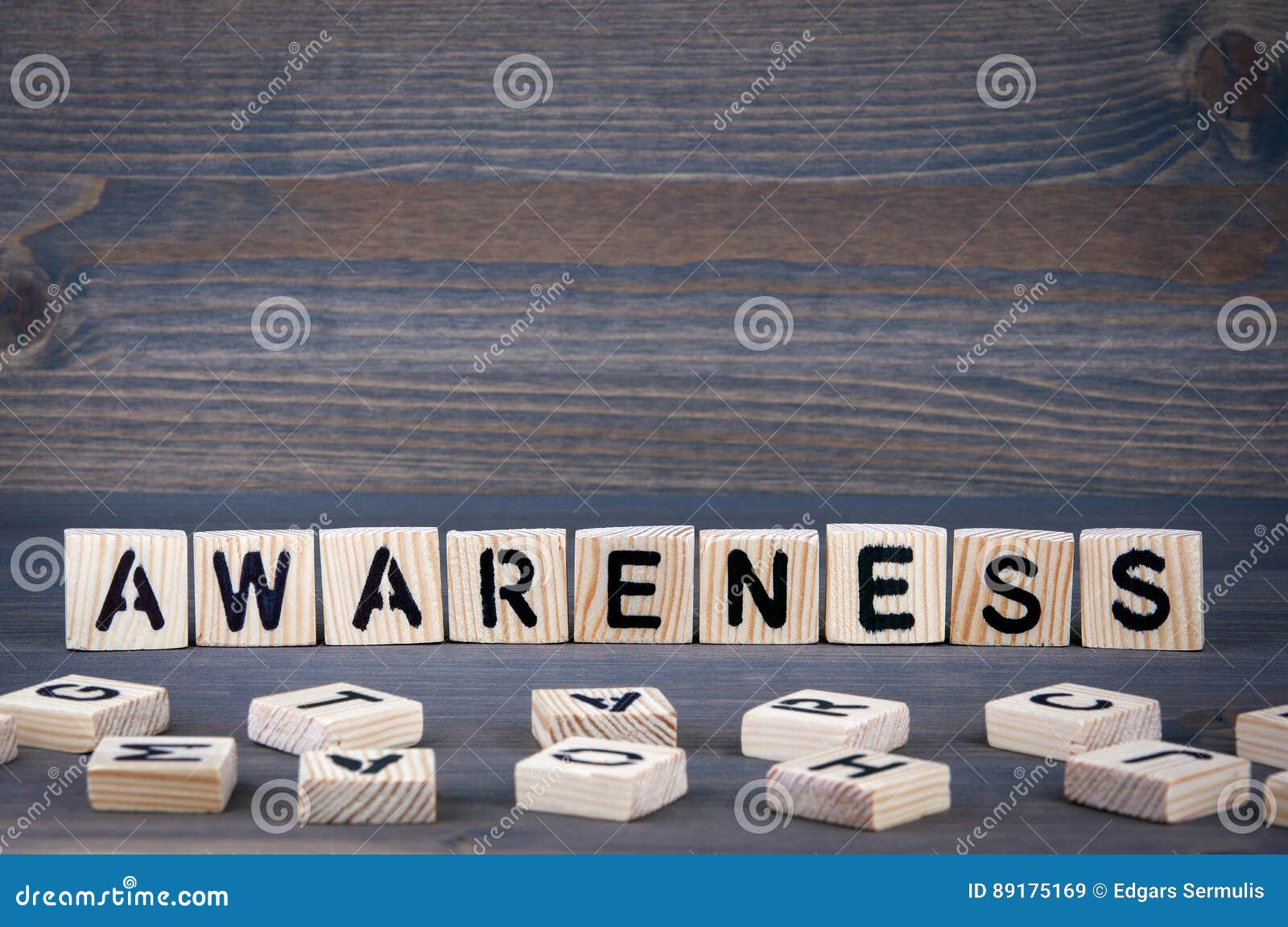 awareness word written on wood block. dark wood background with texture