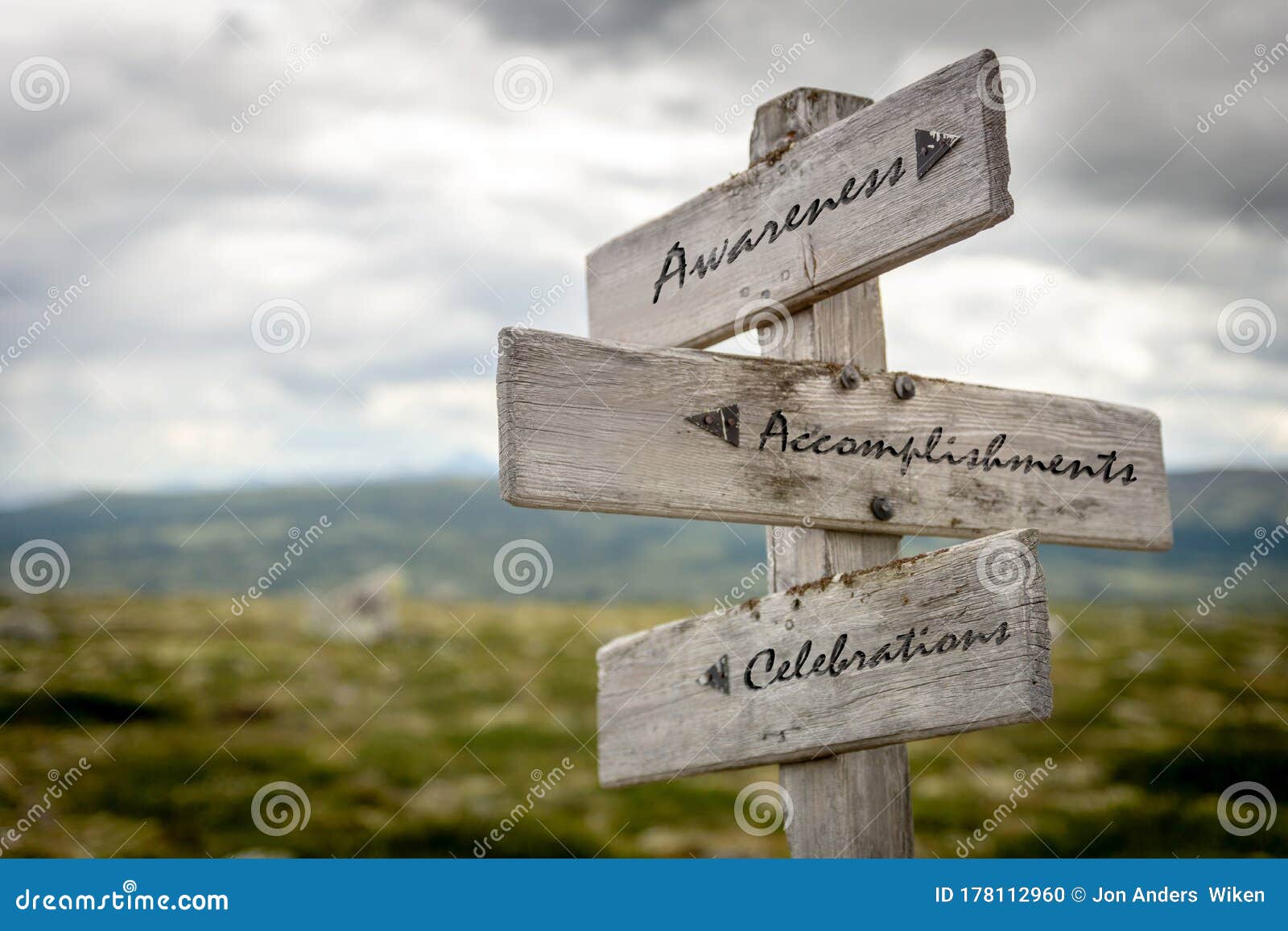 awarness, accomplishments and celebrations text on wooden signpost outdoors in nature.