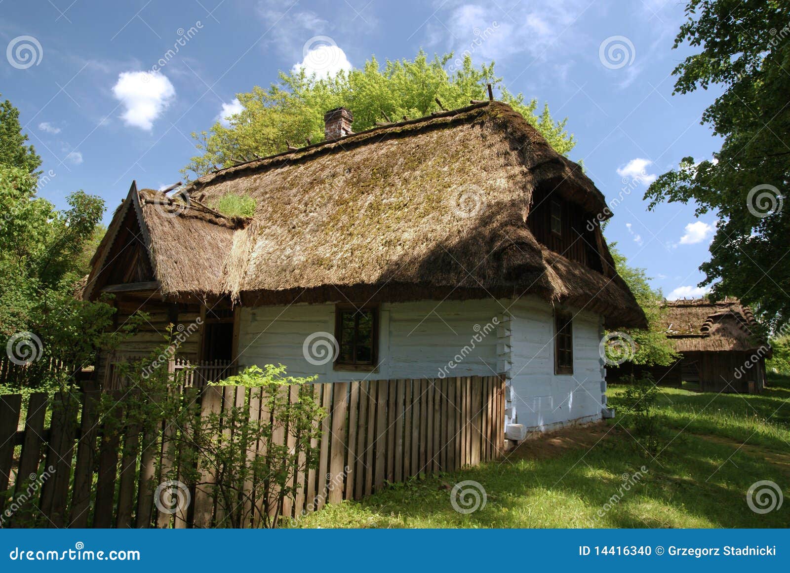 Azienda agricola. Vecchia casa della parete del libro macchina con il tetto del thatch e la rete fissa di legno