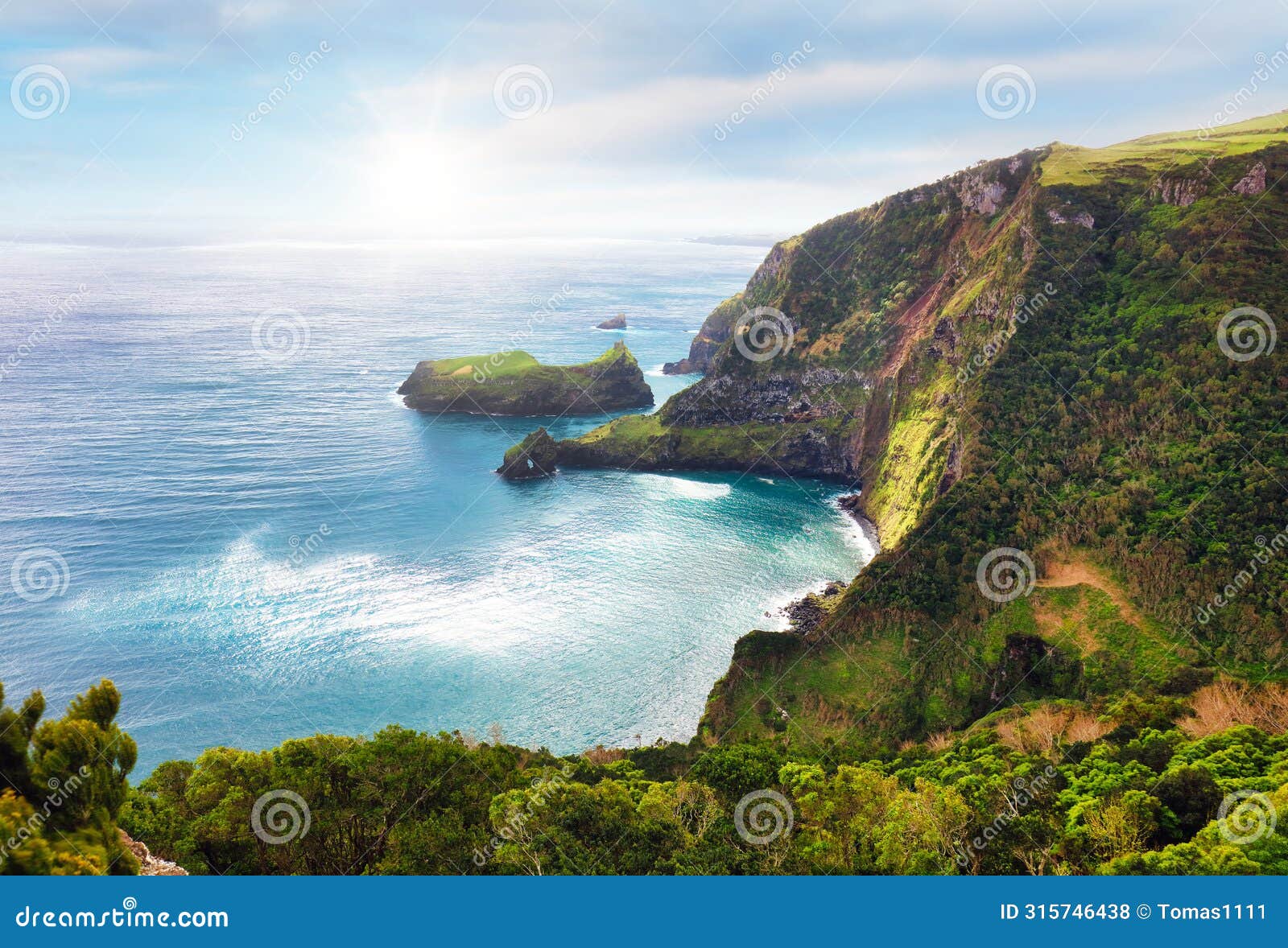 azores - flrores island - view from miradouro do ilheu furado towards the atlantic ocean and the sea cliffs with sun and blue sky