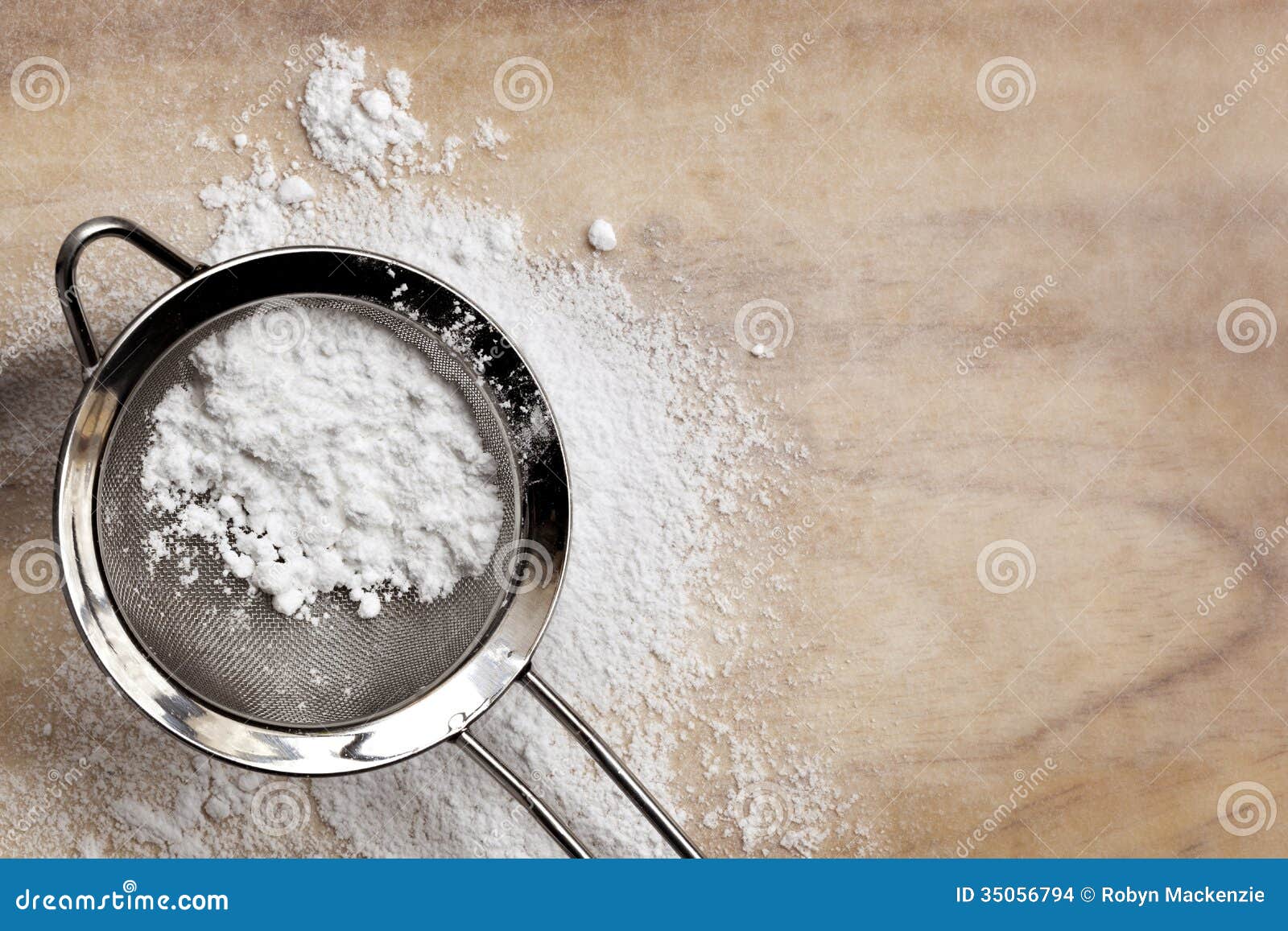 Açúcar de crosta de gelo. Açúcar da crosta de gelo ou do pasteleiro na peneira, sobre o papel do cozimento.