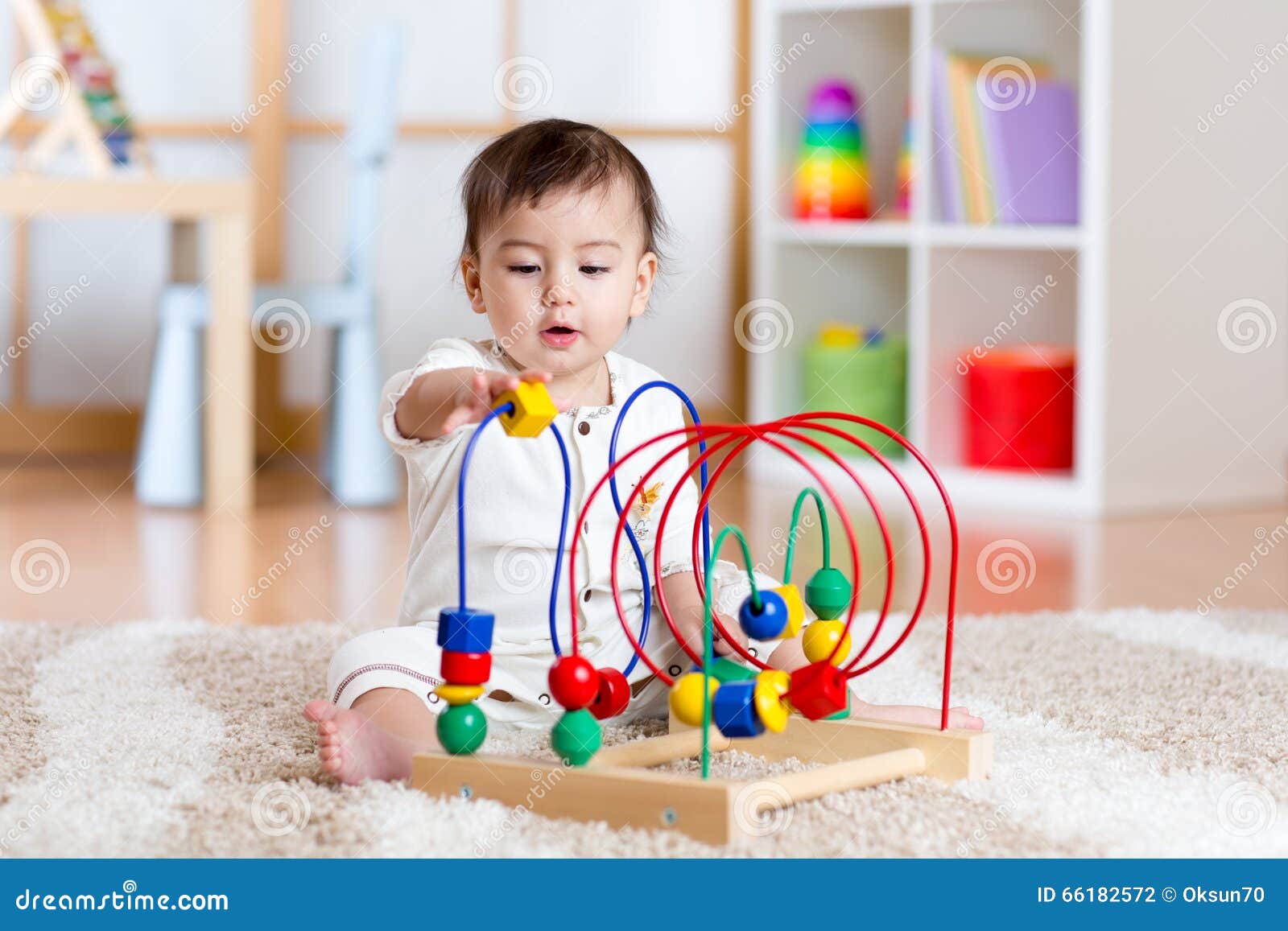 Bébé Jouant Avec Le Jouet éducatif Dans La Crèche Photo stock