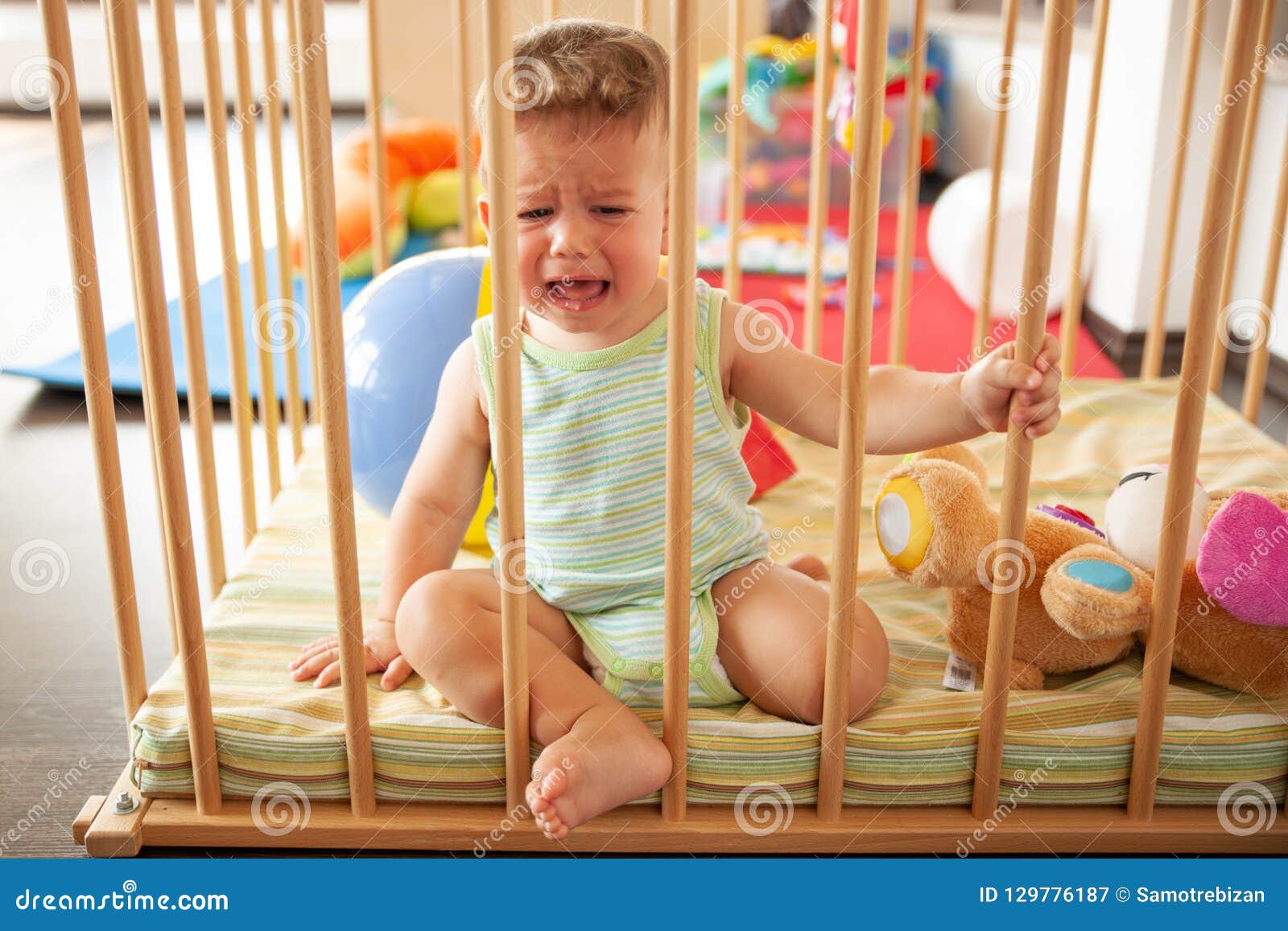 Bebe Mignon Pleurant Triste Regardant Par Les Barres En Bois De Sa Huche Ou Parc A L Interieur Dans La Creche Image Stock Image Du Colore Caucasien