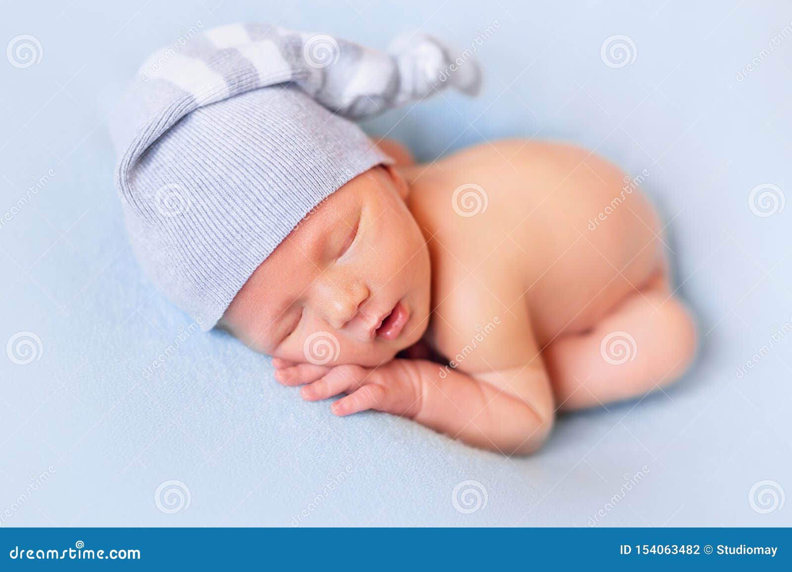 Bébé Nouveau-né De Sommeil Sur Le Fond Bleu Enfant Dans Un Bonnet De Nuit  Photo stock - Image du visage, innocent: 154063482