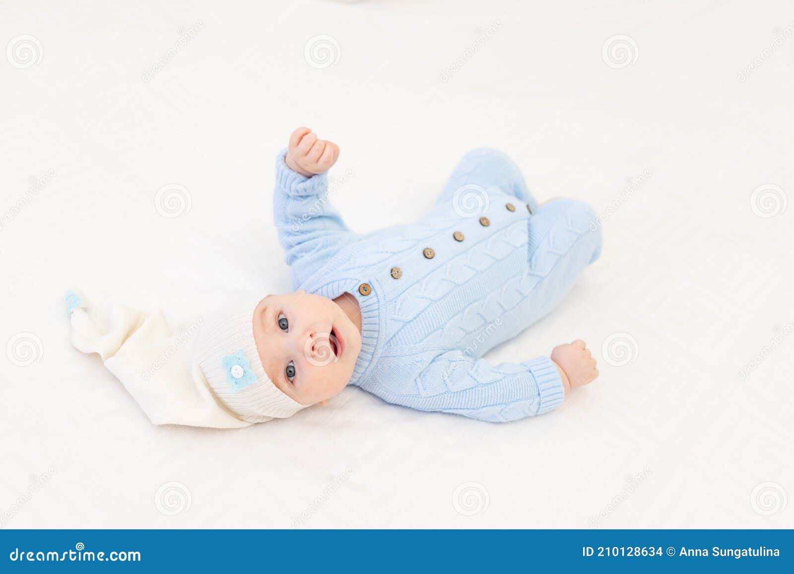 Baby on the Bed in a Sleeping Cap. Textiles and Bedding for Children