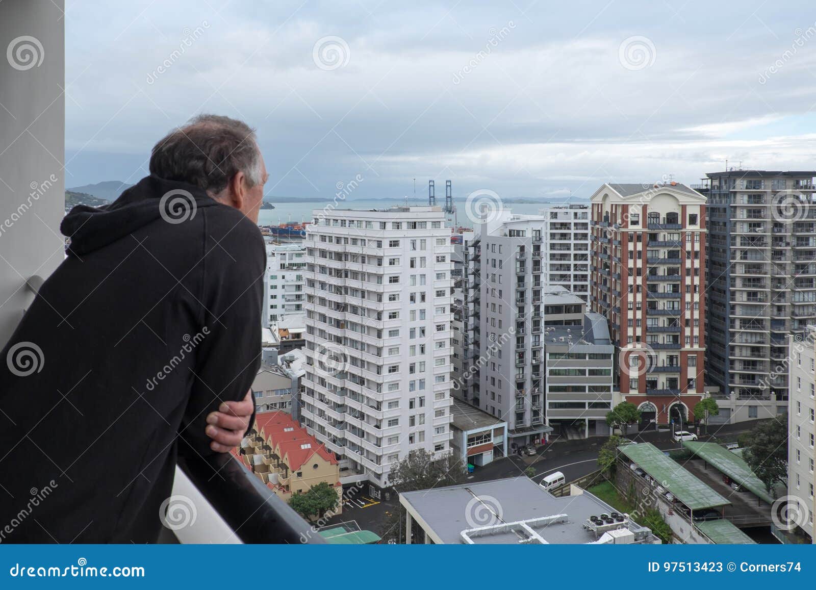baby boomer retired man looks at view of apartment buildings in
