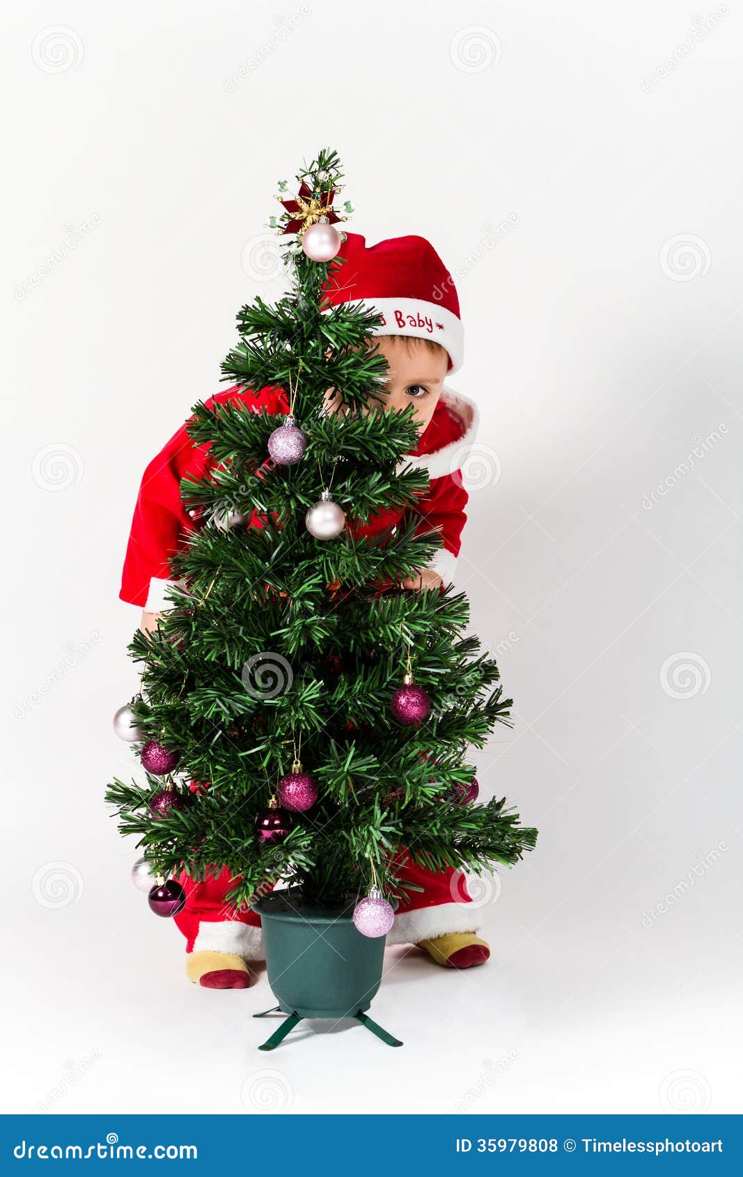 Baby Boy Dressed As Santa Claus Hiding Behind Christmas Tree Royalty ...