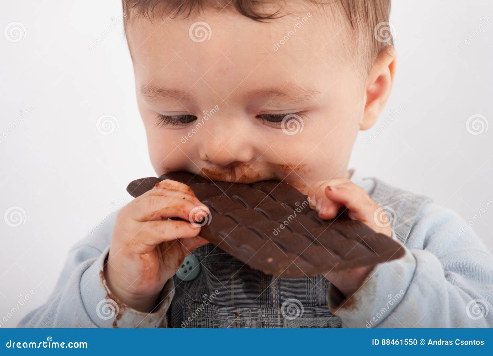 Baby boy eating chocolate stock photo. Image of cheerful 88461550