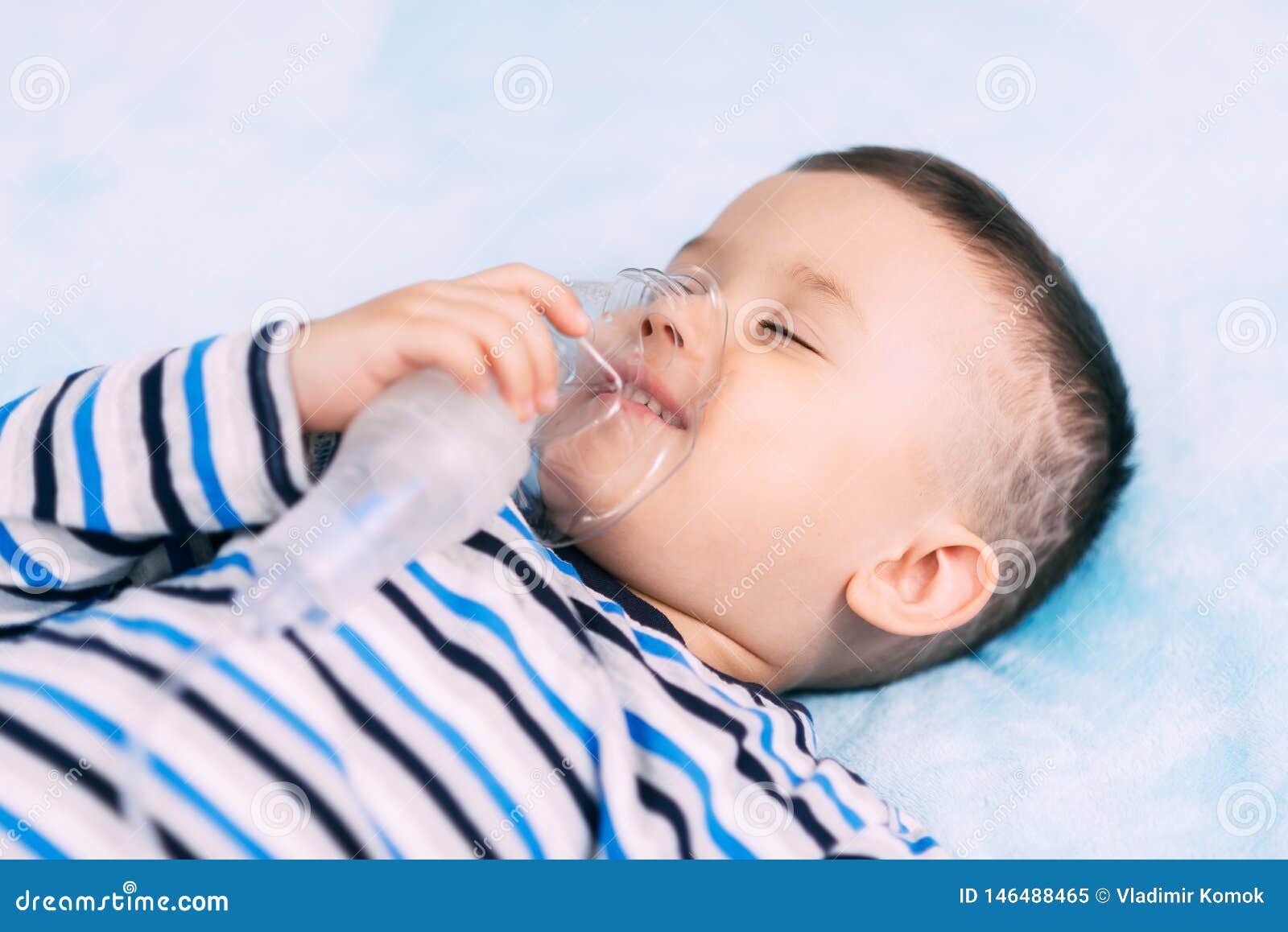 Baby Boy Holding a Mask Immobilizer Sprayer while Taking a Breath Stock