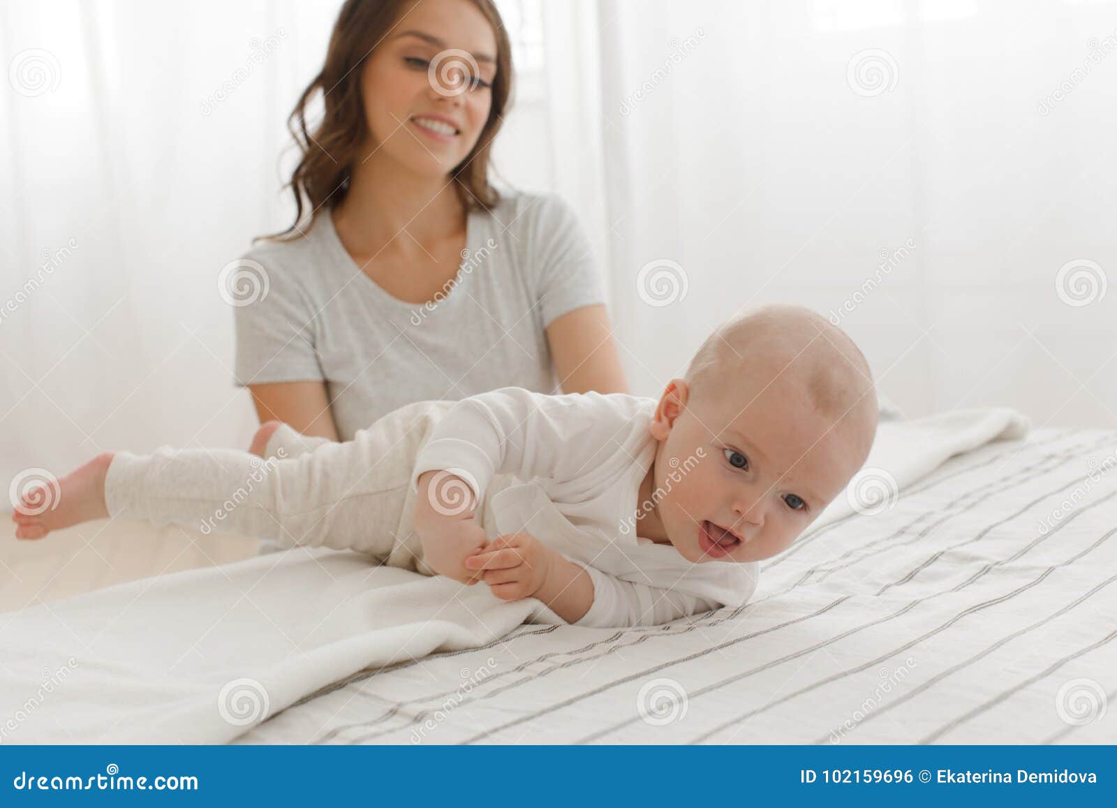 Baby Boy Learns To Roll Over on His Back on Bed Stock Photo - Image of ...