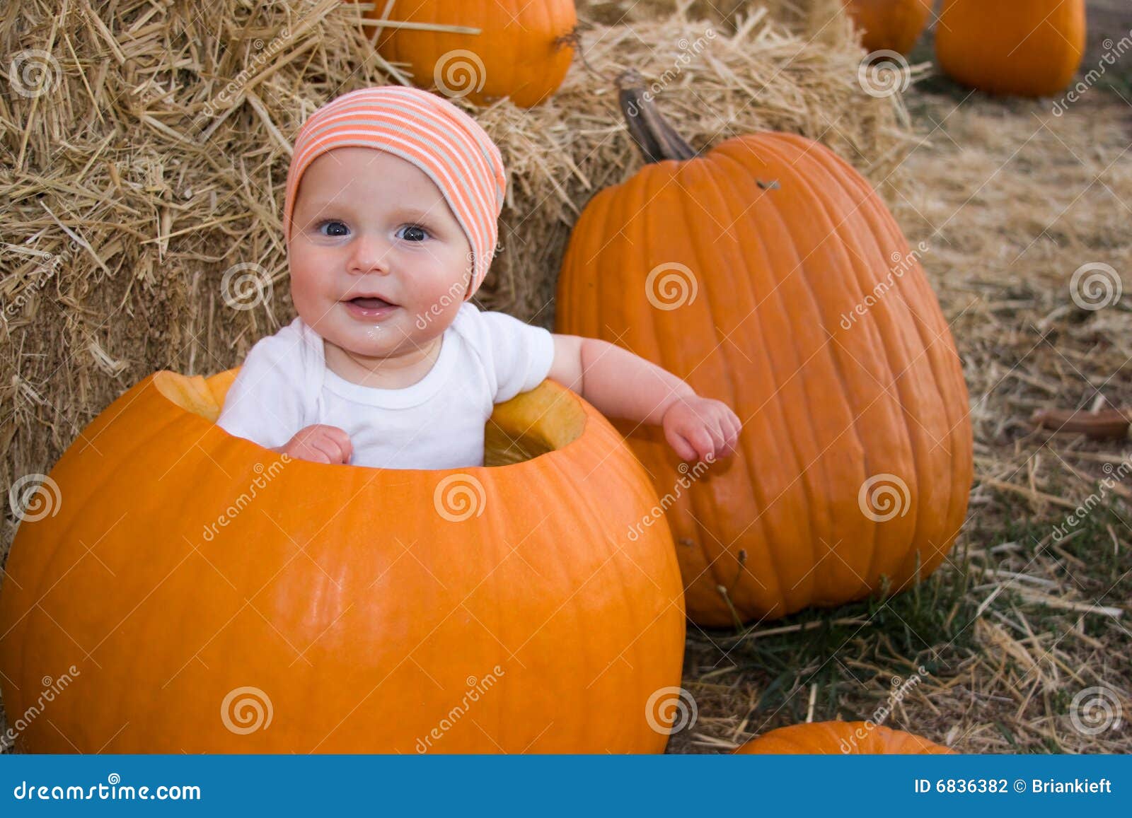 baby boy sat in pumpkin