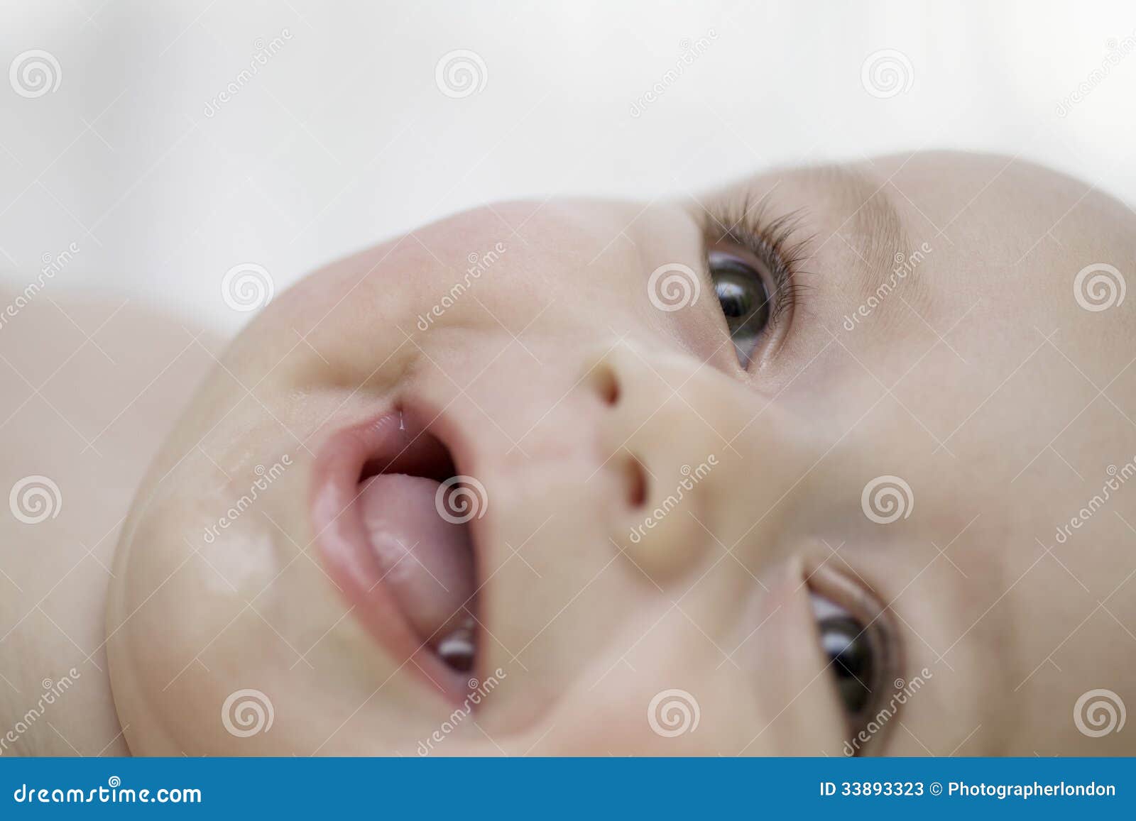 Happy Gurgling Baby Lying On His Bed RoyaltyFree Stock Photo
