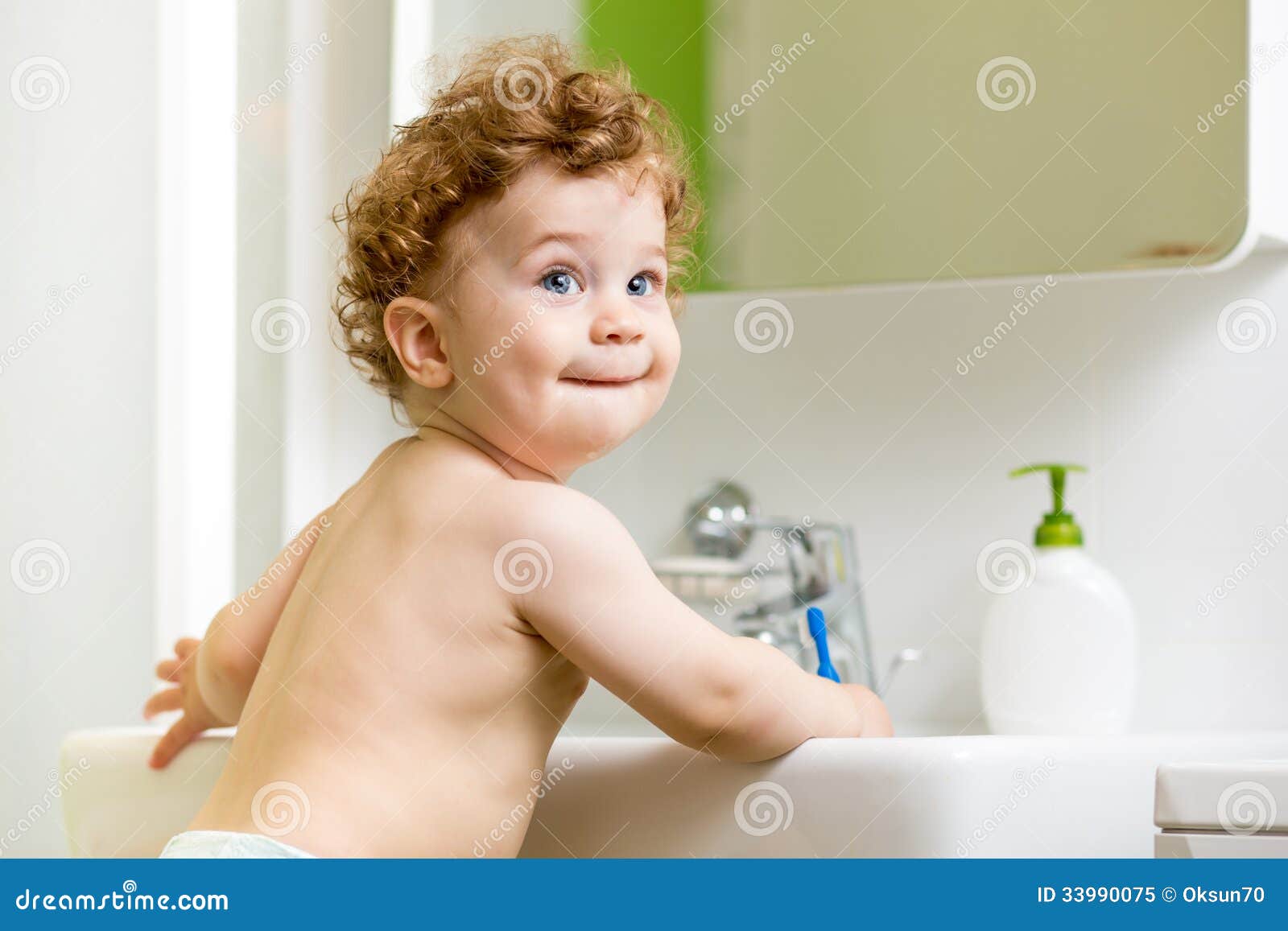 baby brushing teeth in bathroom