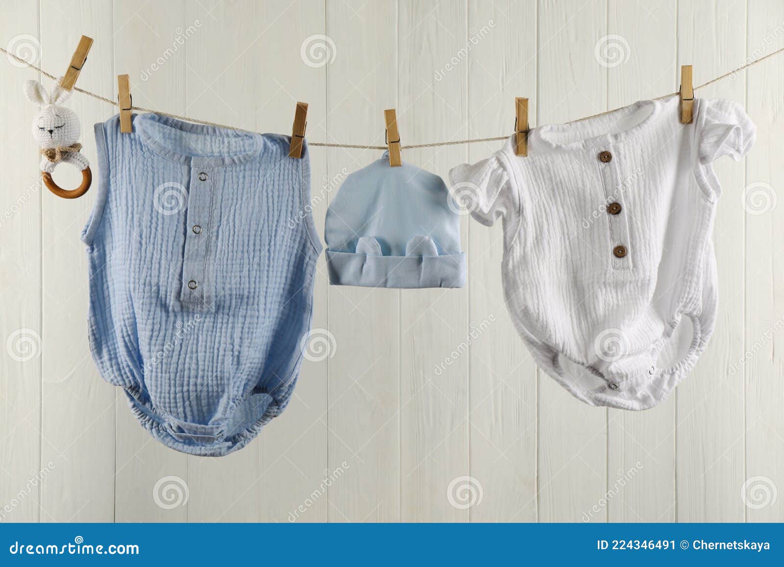 Baby Clothes and Accessories Hanging on Washing Line Near White Wall ...
