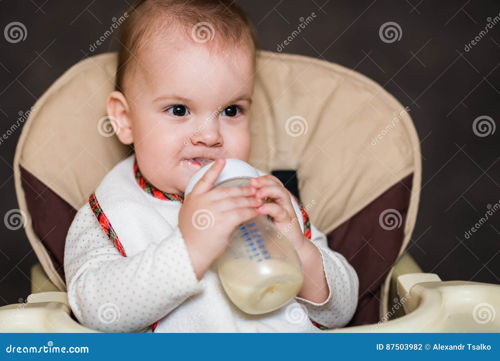 Baby Drinking Milk from a Bottle in the Apartment Stock Photo Image