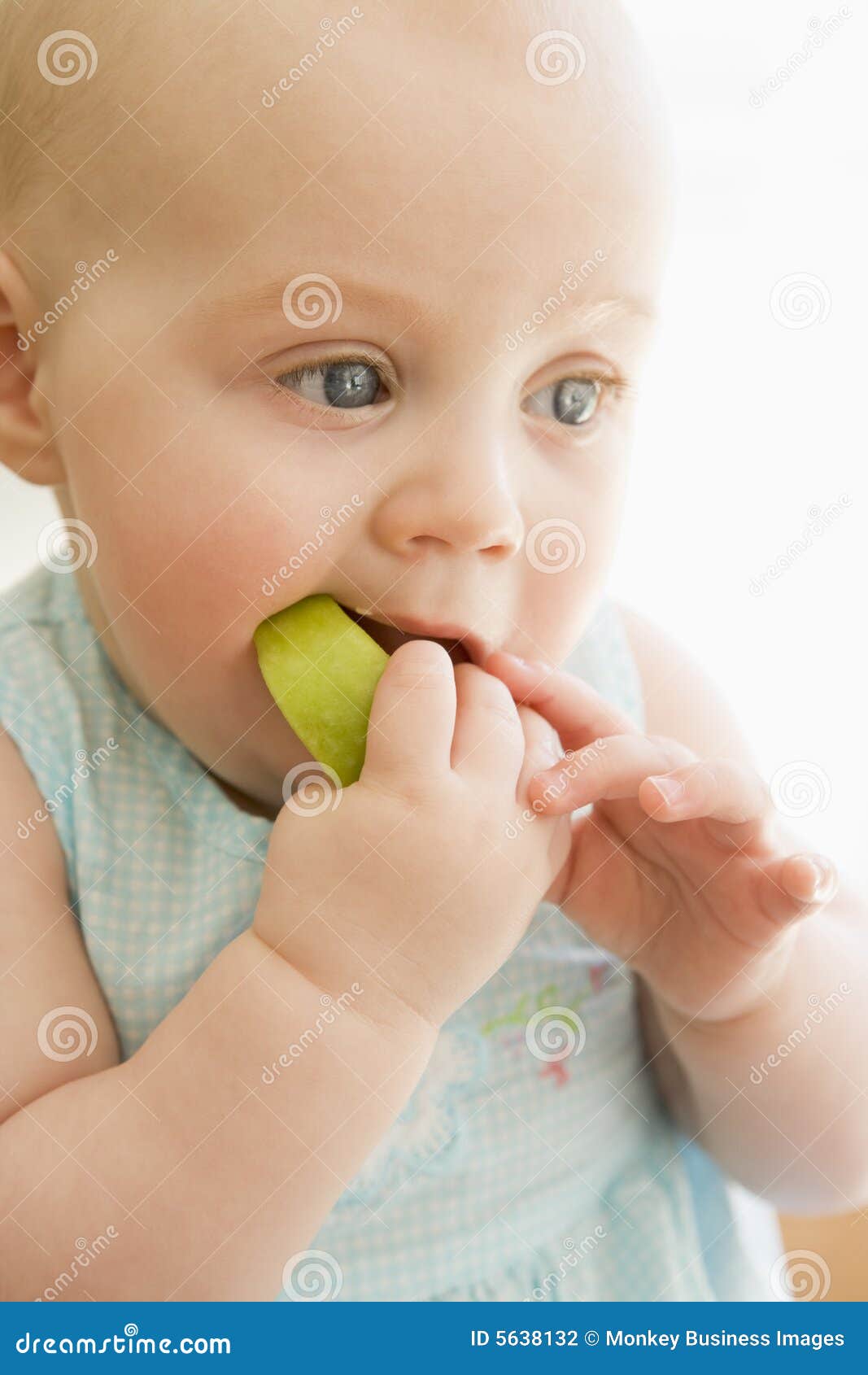 baby eating apple indoors