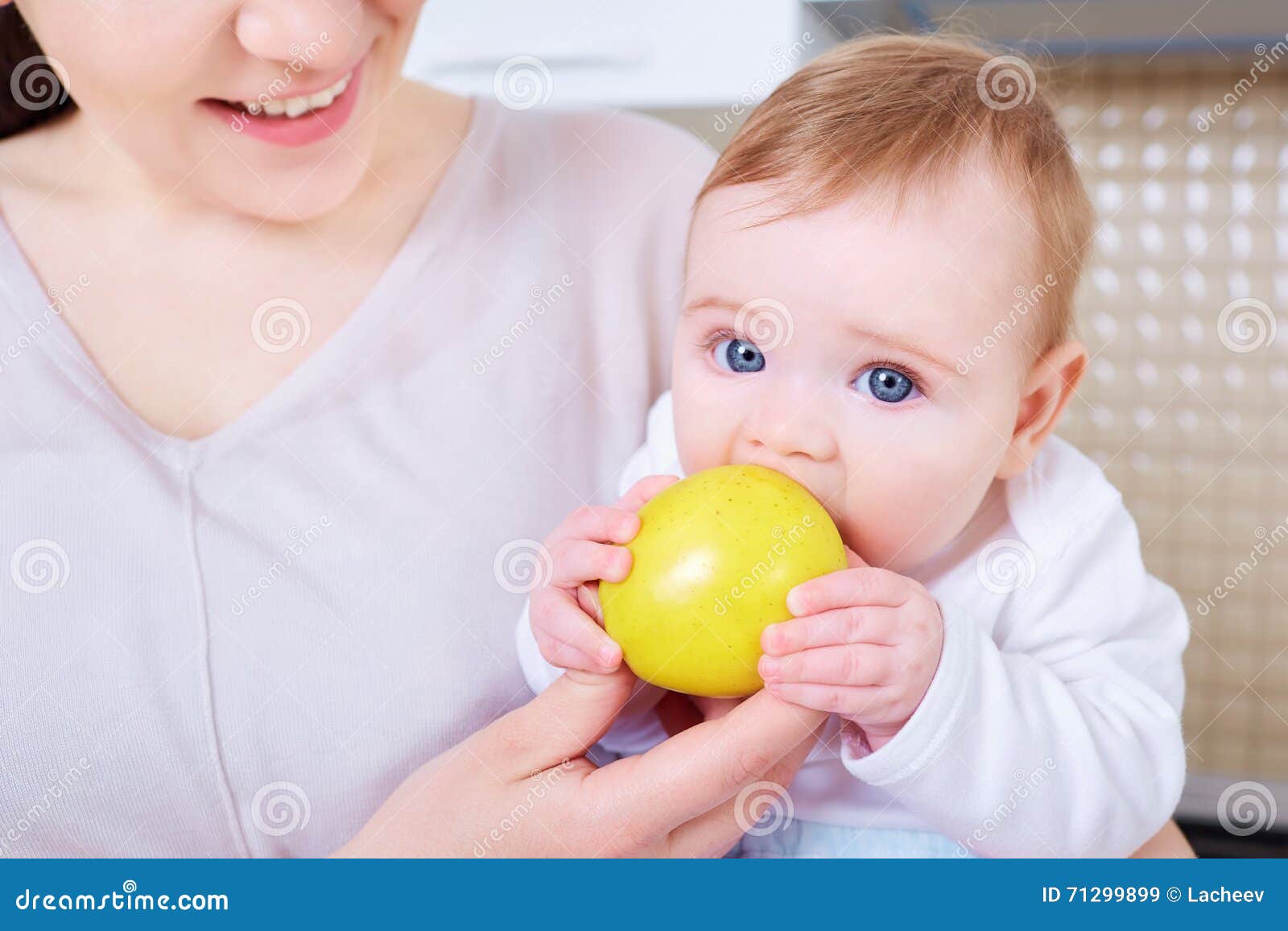 baby eats yellow apple.child