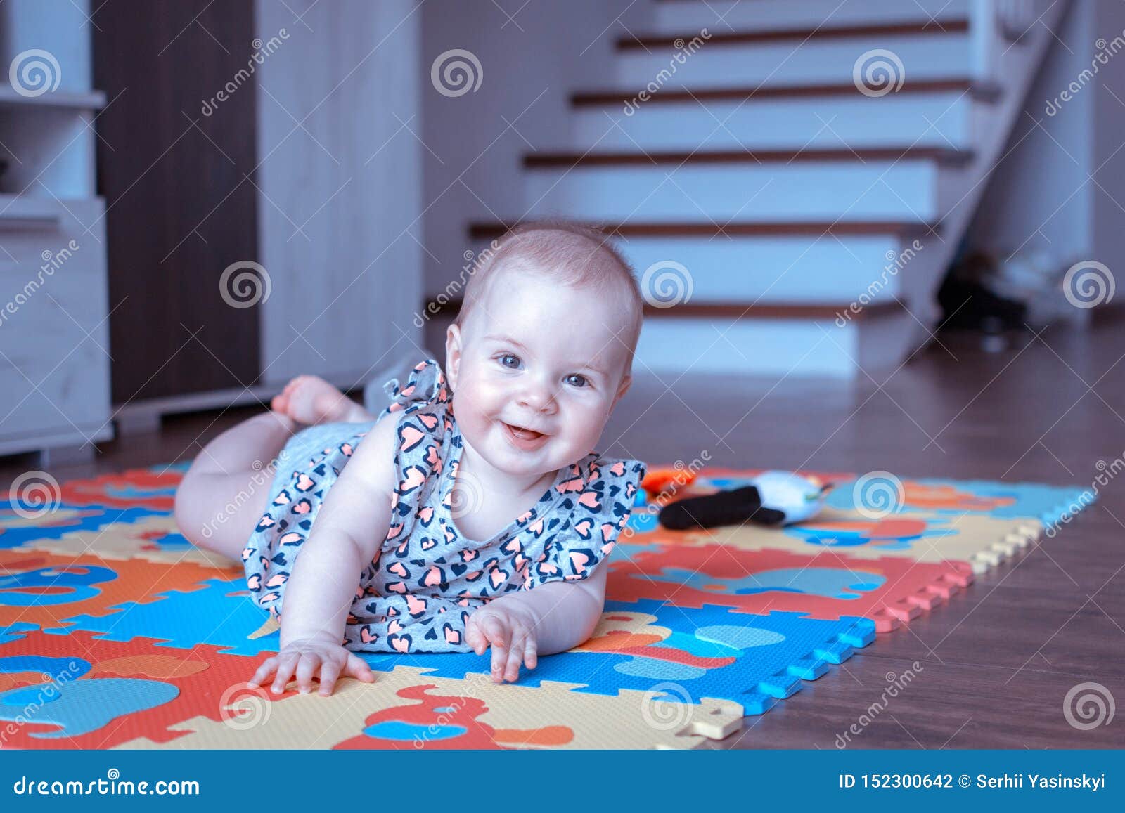 Baby Girl Doing Tummy Time On Colorful Play Mat Stock Photo