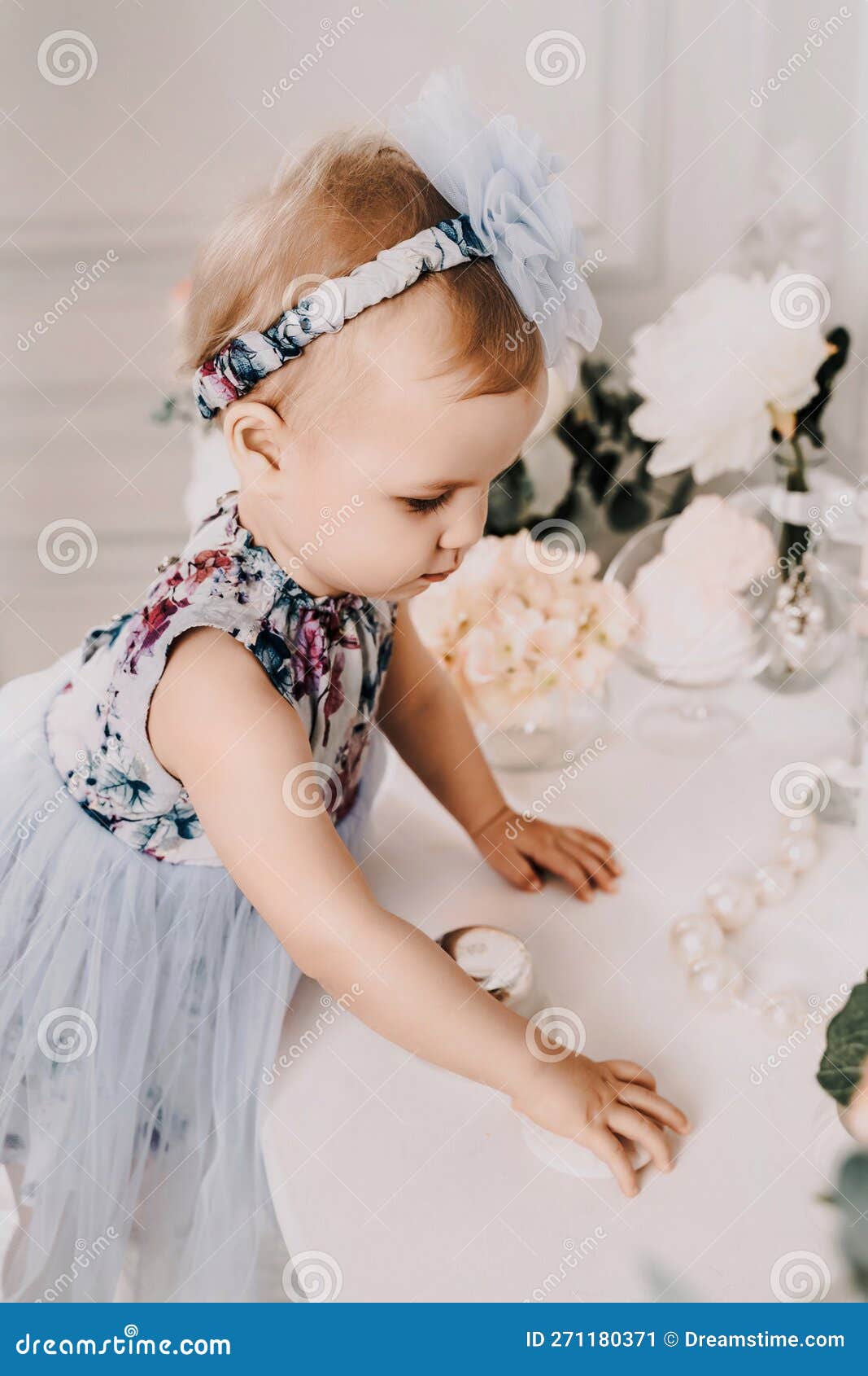 Baby girl elegant dress. A one-year-old girl in a puffy skirt and a white  T-shirt poses against the backdrop of a bright room with a yellow tulip in  Stock Photo - Alamy