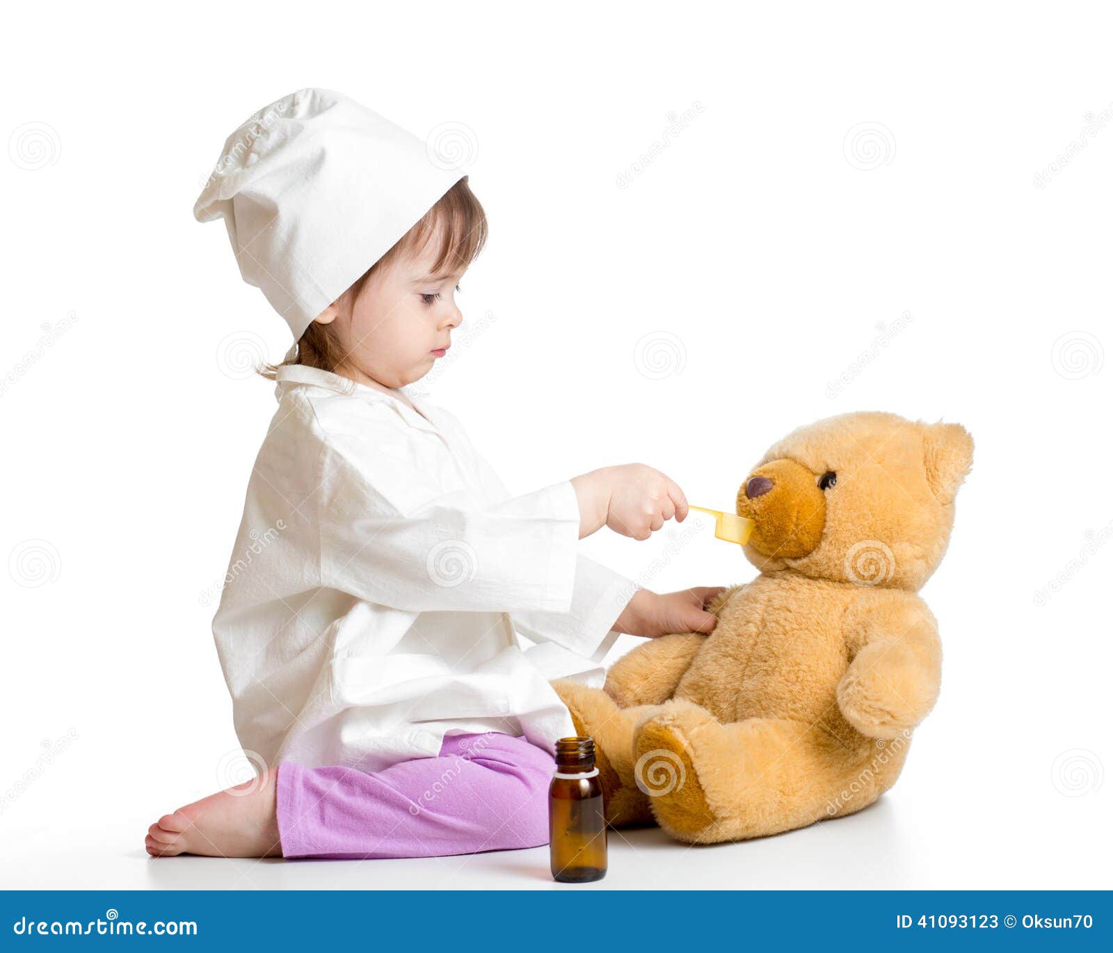 baby girl playing doctor and giving remedy to toy