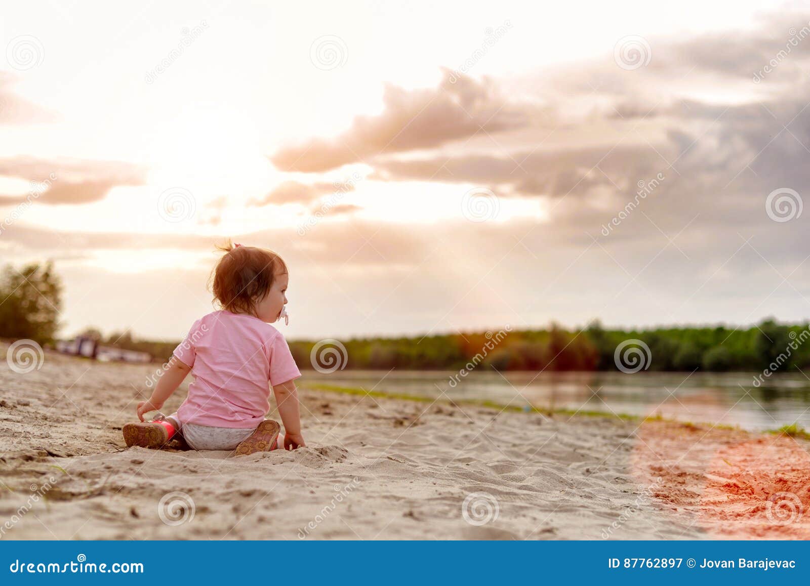 Baby girl on a river shore stock image. Image of sand 87762897