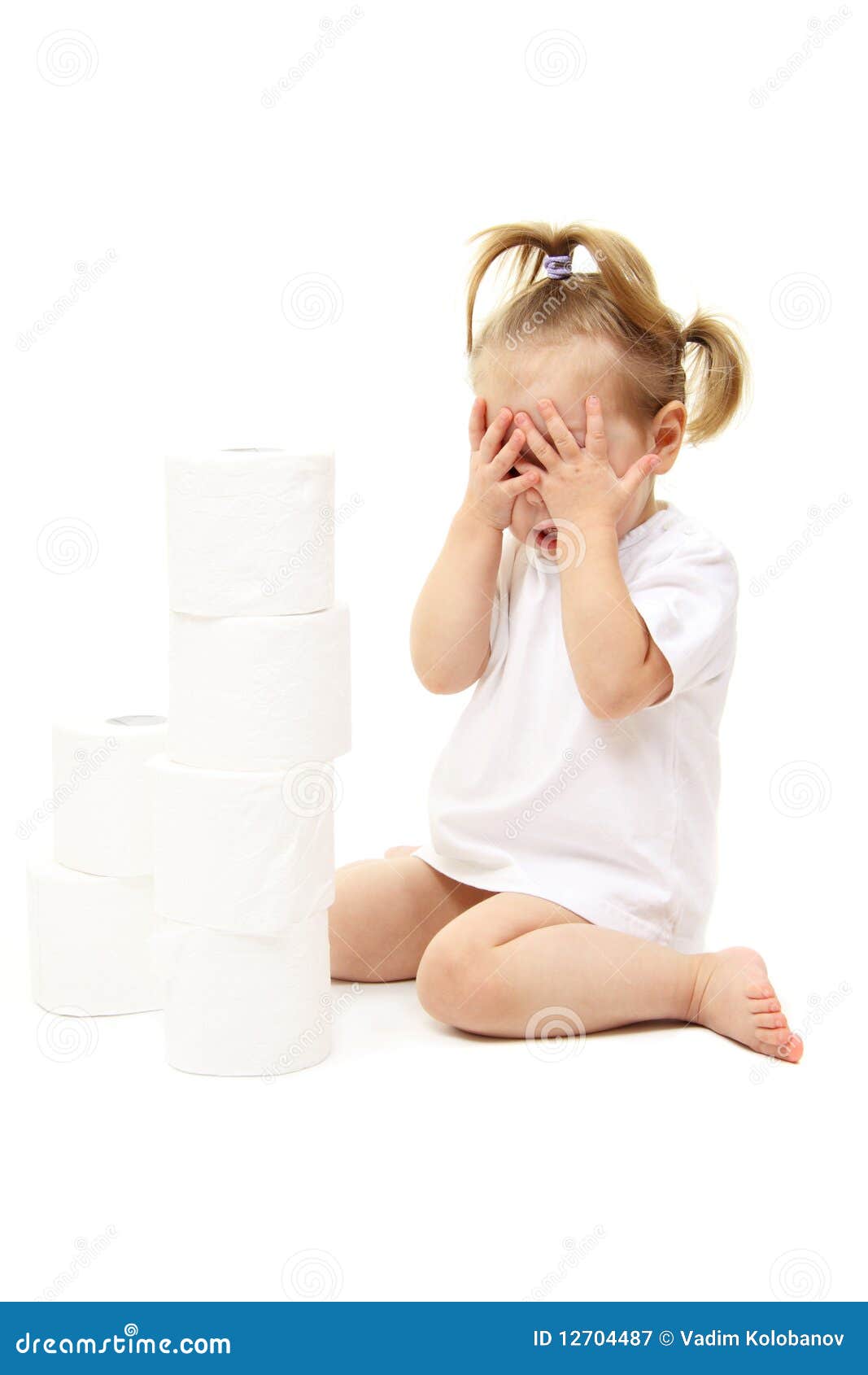 Toddler girl in underwear pulling at toilet roll - Stock Image