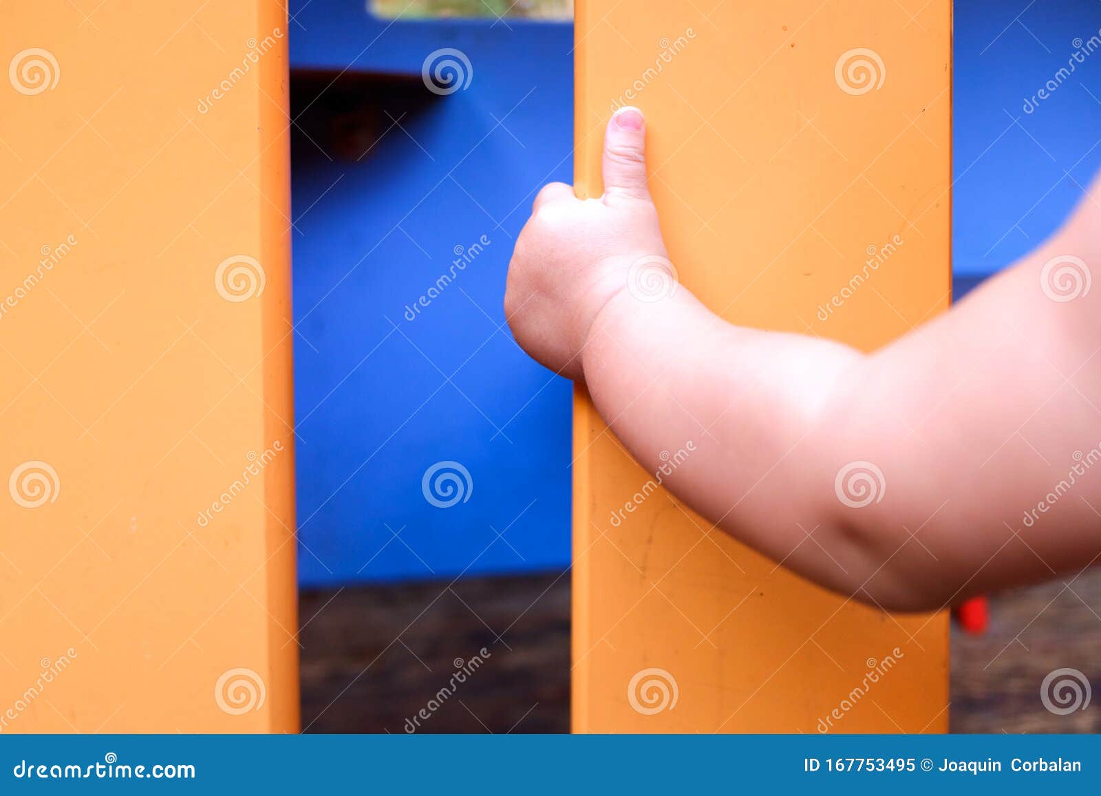 A Baby Grabs a Wall while Learning To Walk by Itself Stock Image
