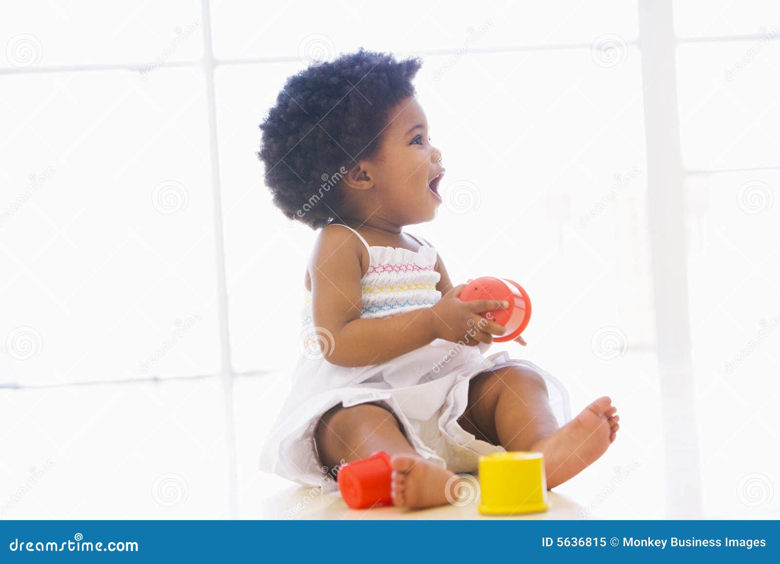 baby indoors playing with cup toys