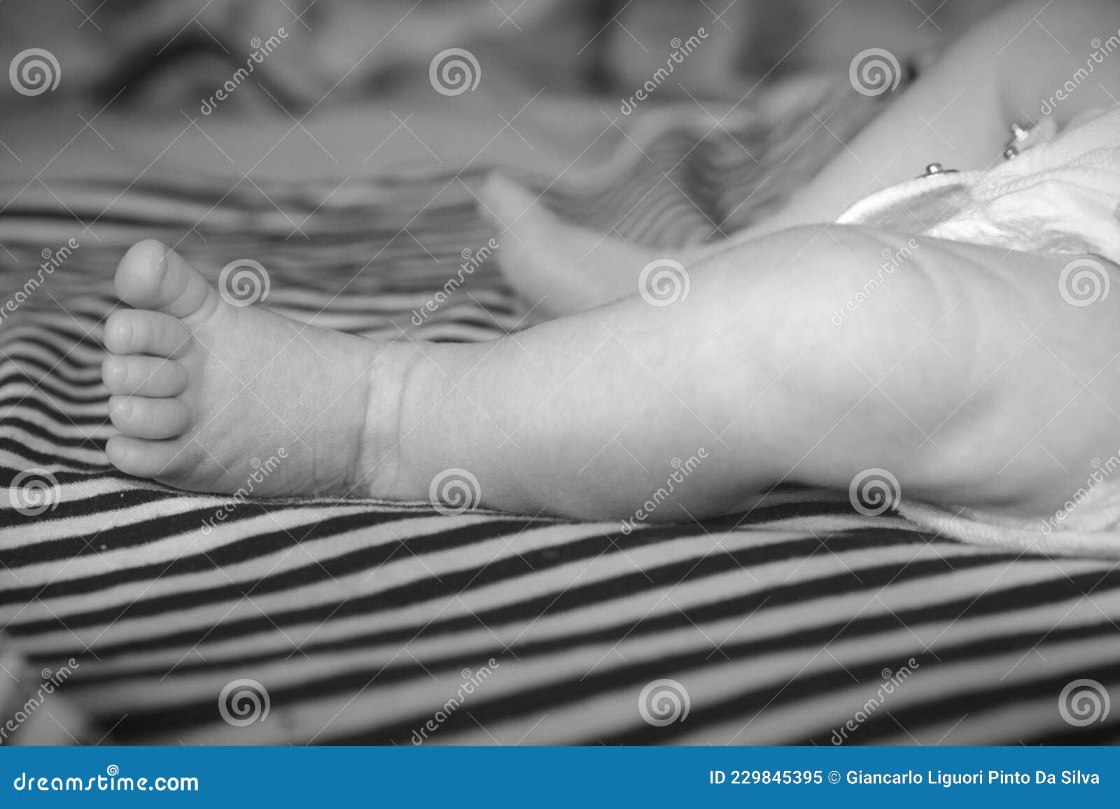 Baby leg lying on a bed stock image. Image of childcare 229845395