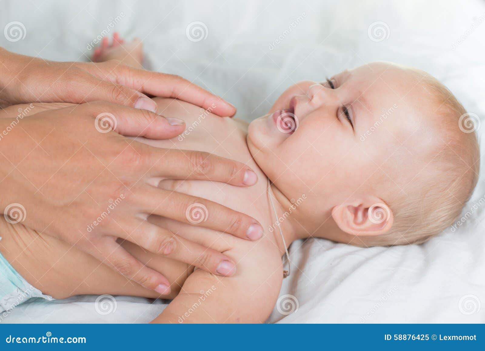 baby massage. mother massaging infant belly