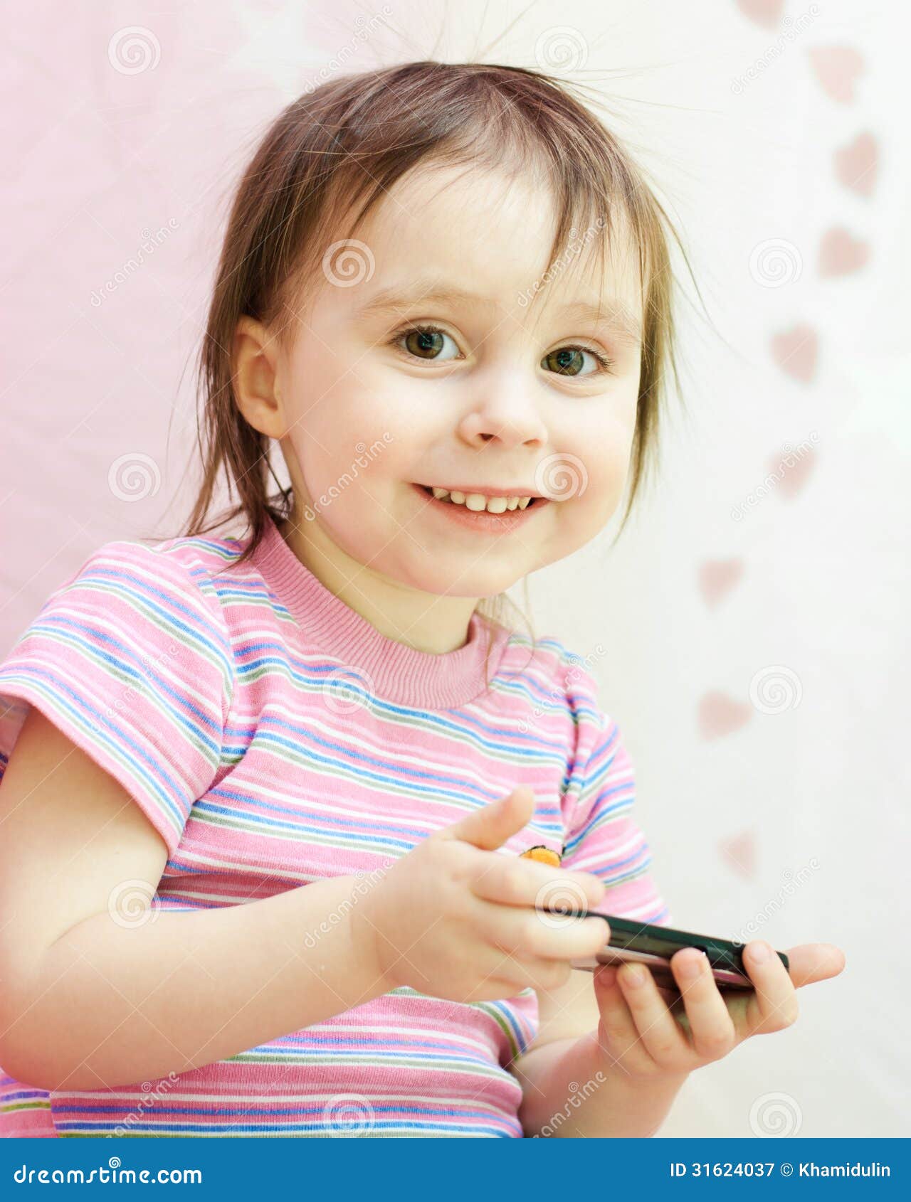 Baby met mobil telefoon op een roze achtergrond.
